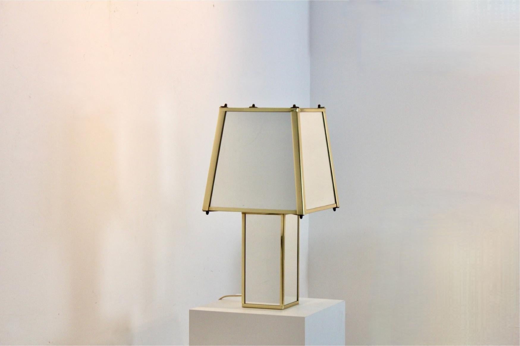 Lampada da tavolo geometrica in ottone e specchio, Belgio, anni '70
Questa lampada da tavolo sofisticata e scultorea, realizzata in Belgio negli anni '70, presenta un elegante gioco di geometrie e materiali riflettenti. Il paralume sfaccettato e la