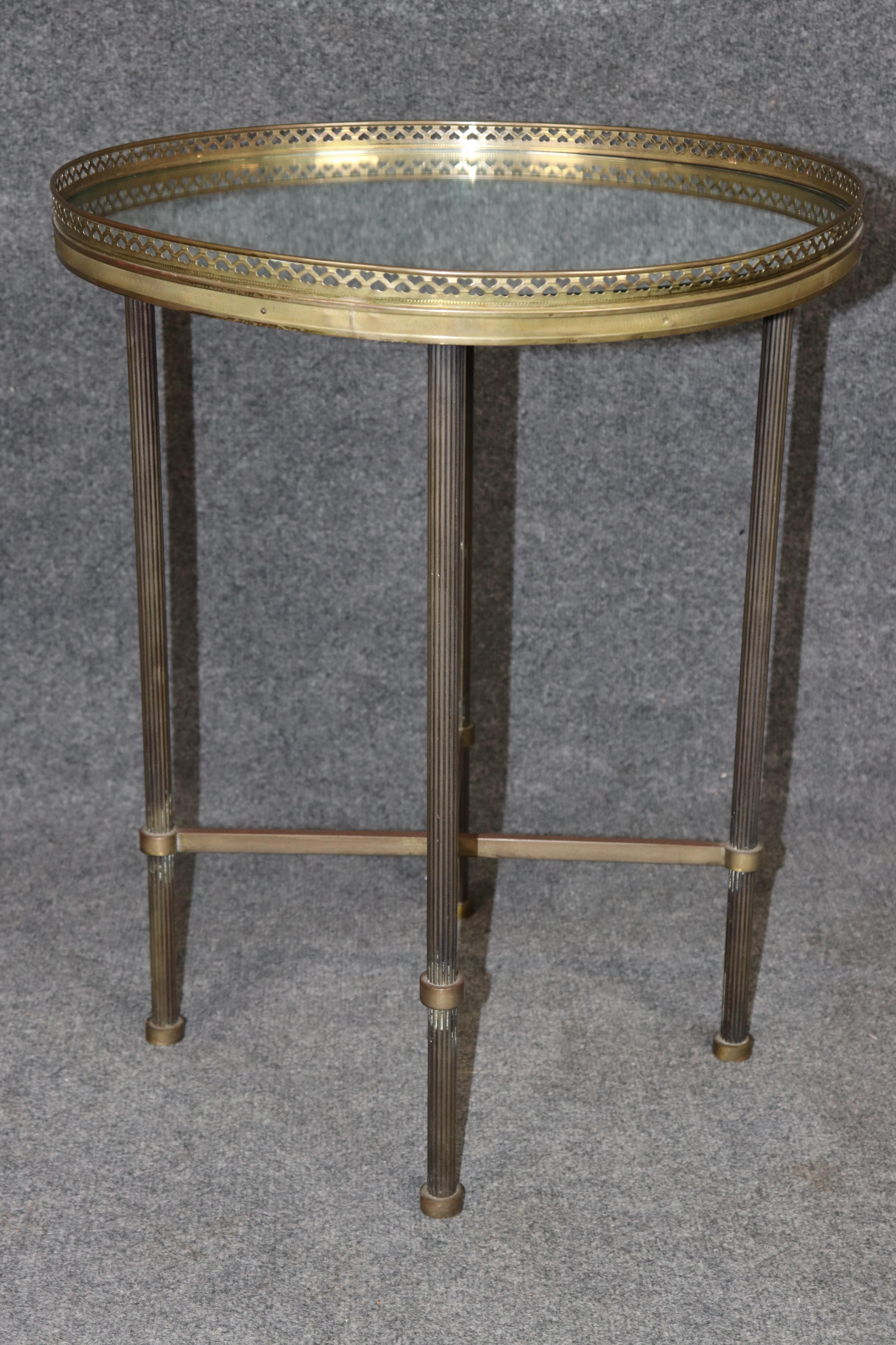 Add a touch of refined Parisian elegance to your space with this vintage French Directoire-style brass and mirrored occasional table. Dating to the early-to-mid 20th century, this antique side table showcases a beautifully patinated brass frame with