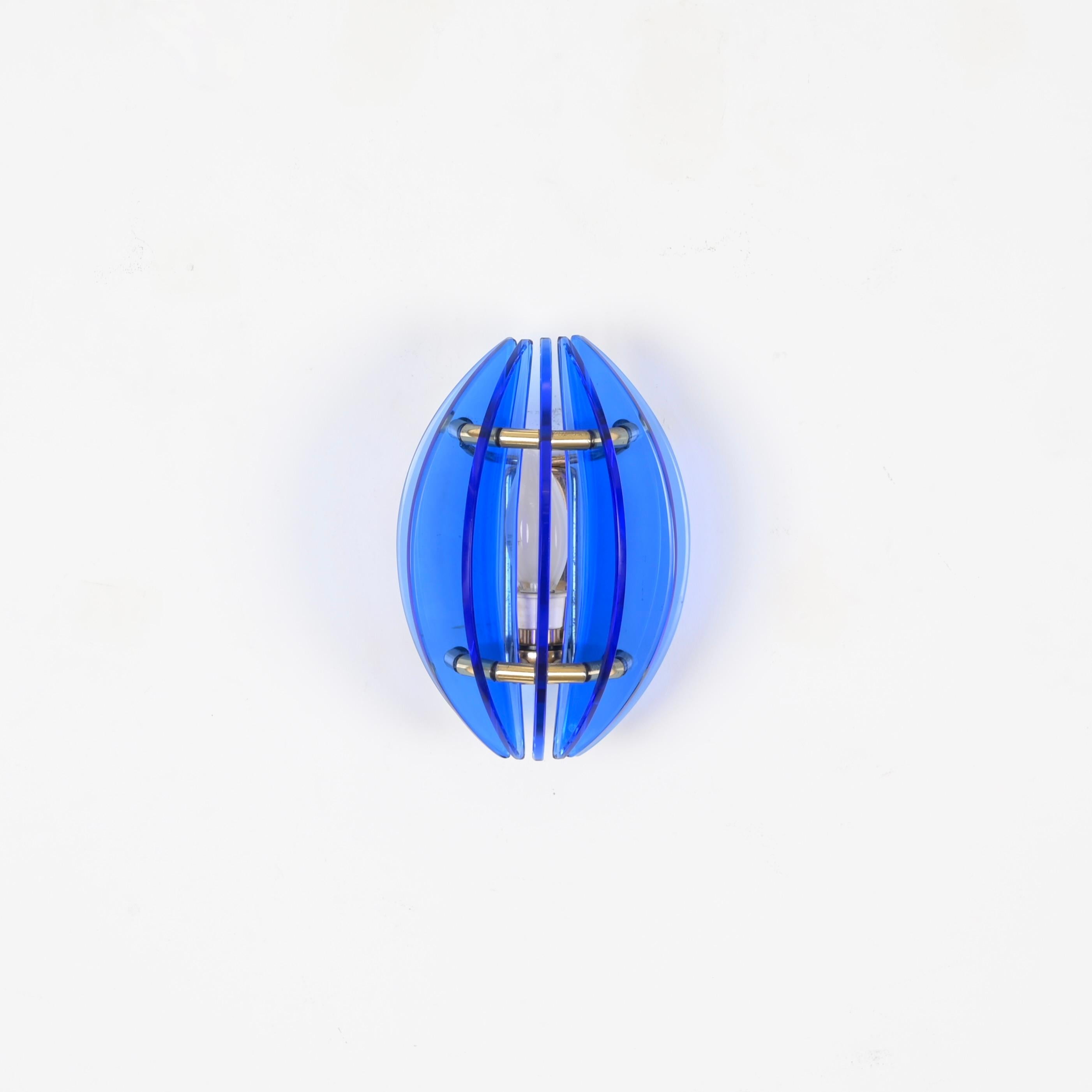 7 Wonderful Mid-Century wall sconce in a vibrant blue Murano glass and solid brass. This gorgeous piece was designed by Galvorame in Italy during the 1970s. 

This elegant wall light features a sinuous shade which consists of 7 crescent-shaped blue