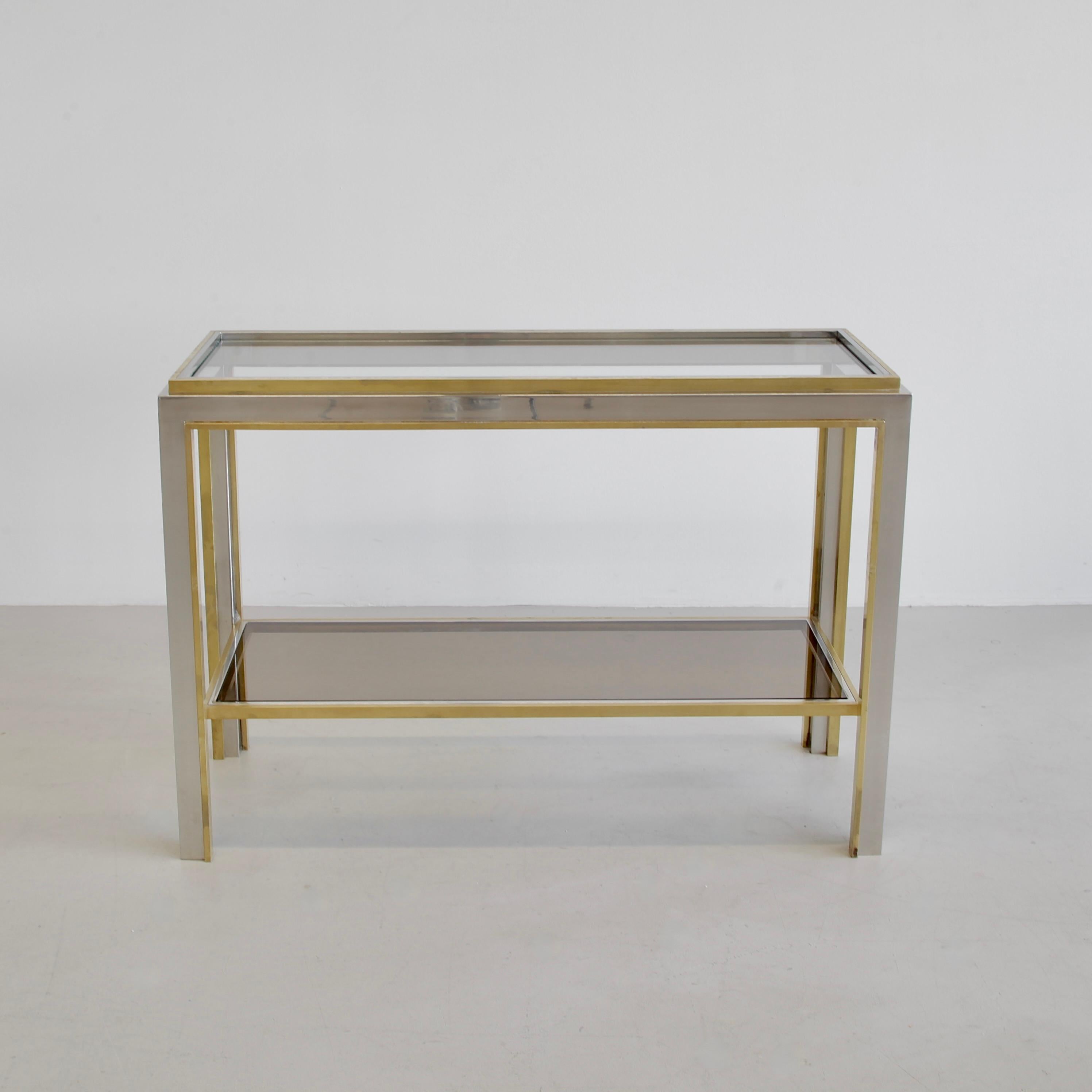 Console Table designed by Romeo Rega. Italy 1970s.

Nickel-plated metal and brass base construction with clear glass top shelf and brown tinted glass on the bottom shelf.
Condition:  

Very good vintage condition.
