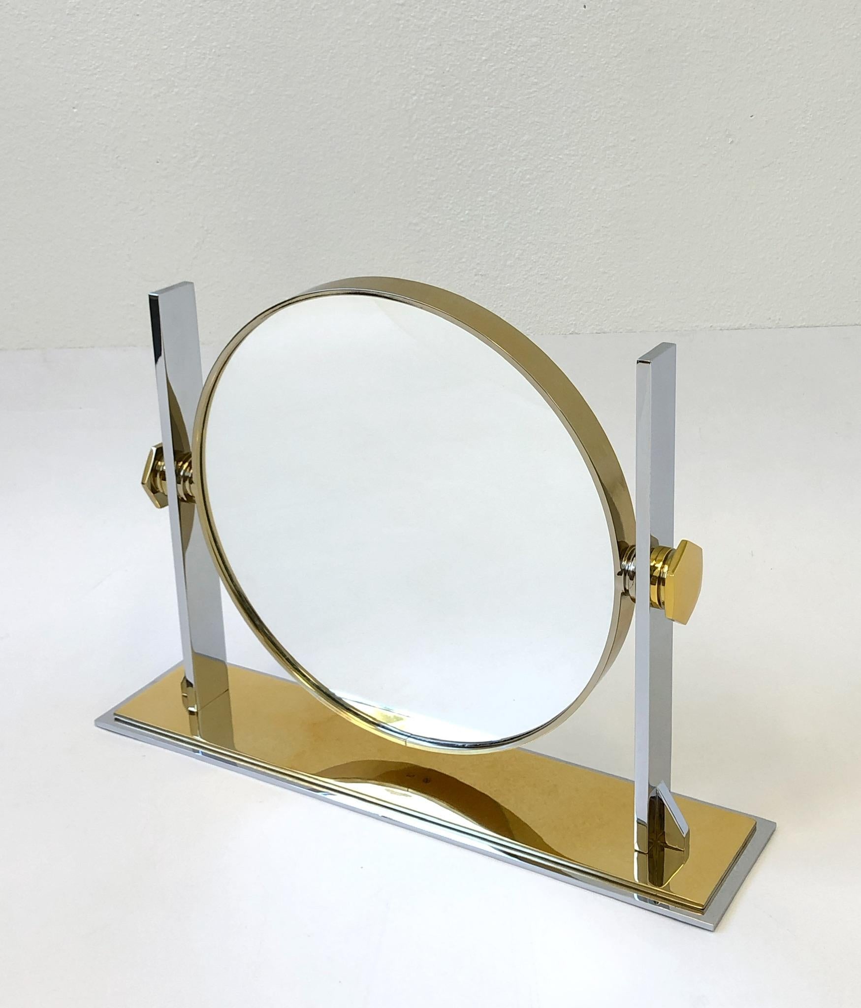 A spectacular polish brass and polish nickel vanity mirror designed by Karl Springer in the 1980s. The mirror can be tilted. The back of the mirror is convex.
Overall dimensions: 19” high 26” wide 6” deep.