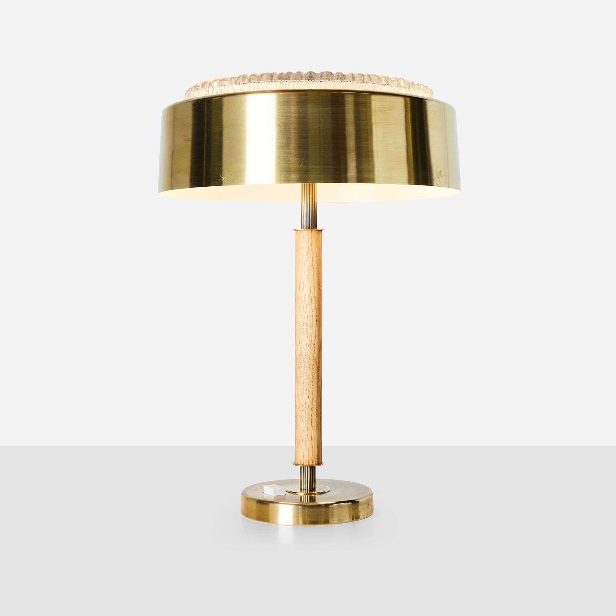 Brass and oak table lamp with glass diffuser, attributed to Bergboms. Brass shade with textured glass top and brass finial. Brass base with embedded switch. Takes two standard bulbs.

Bergboms was a Swedish modernist lighting manufacturer