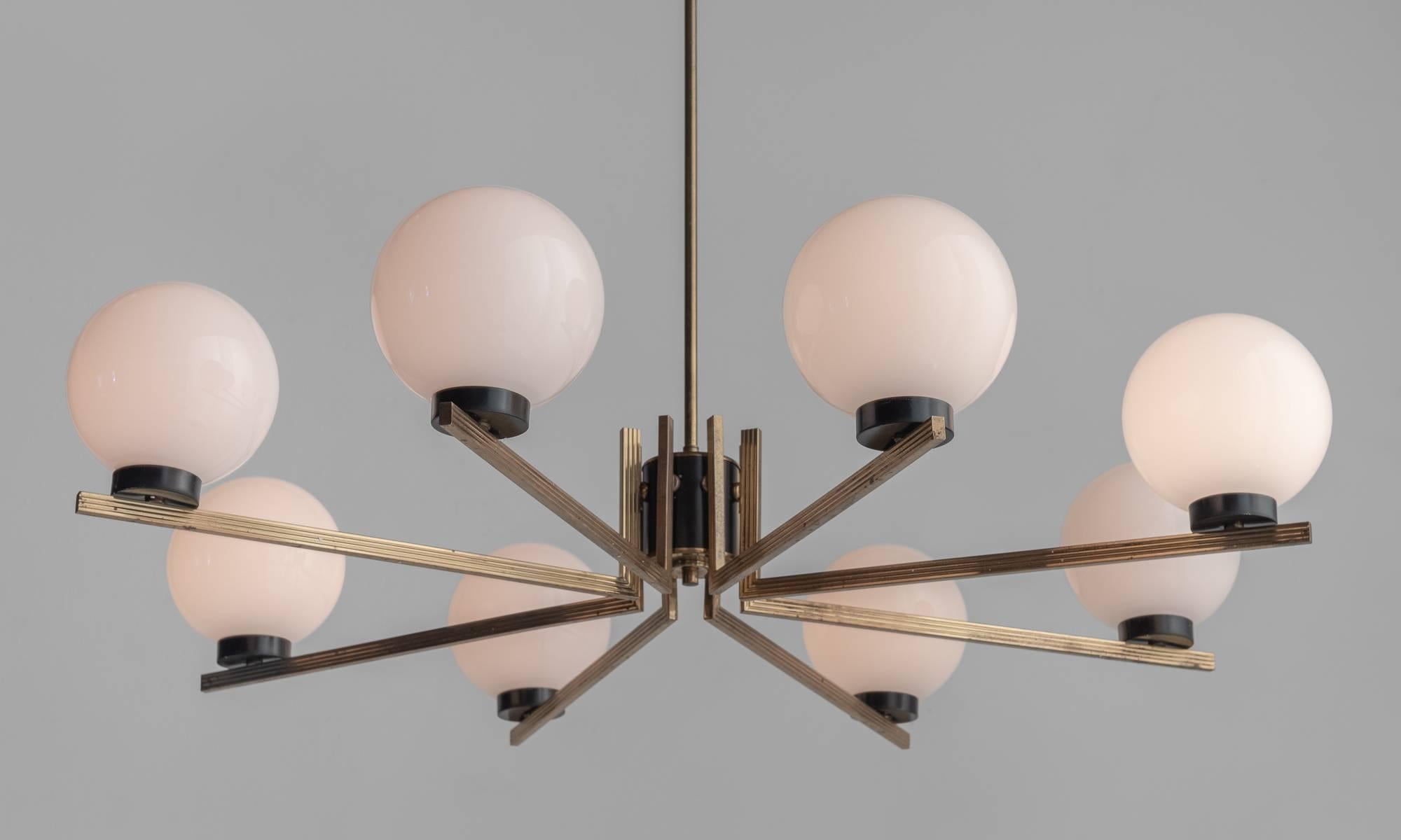 Brass and opaline eight-arm chandelier, France, circa 1955.

Brass and black enameled iron with (8) opaline glass globe shades.

Measures: 36