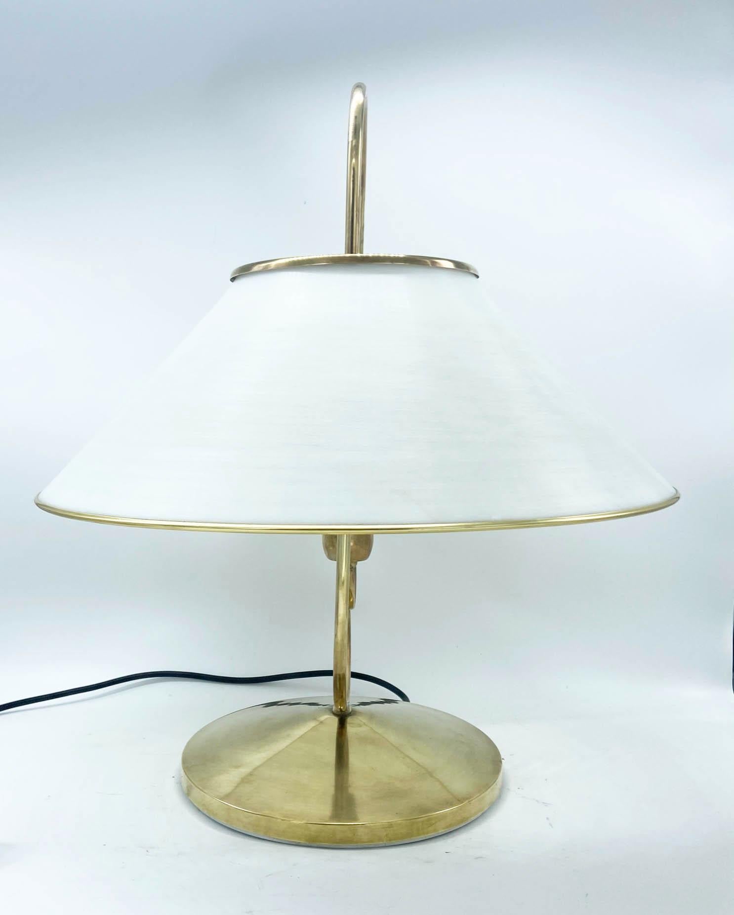 Rare and particular table lamp made of brass with white perspex diffuser.
 The brass base has a particular shape that culminates at the top with a handle that comes out of the diffuser. 
This lamp is a simple yet elegant design that will fit