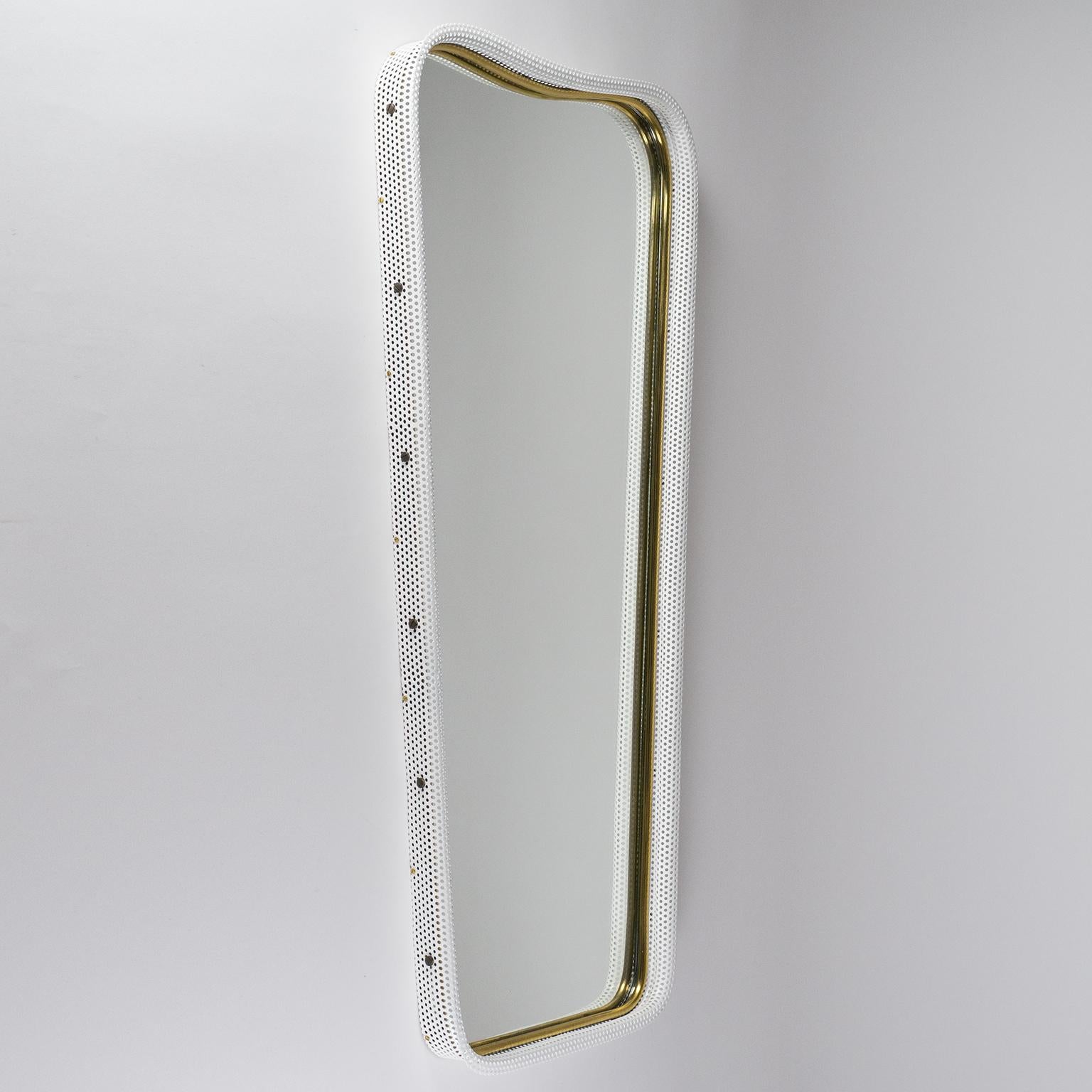 Very unique midcentury wall mirror with a beveled perforated metal frame in white and a tubular brass inner rim. Excellent craftsmanship with original mirror in very good shape.
Measures: Total height 31.5 inches/ 80cm, width at the top 15.8