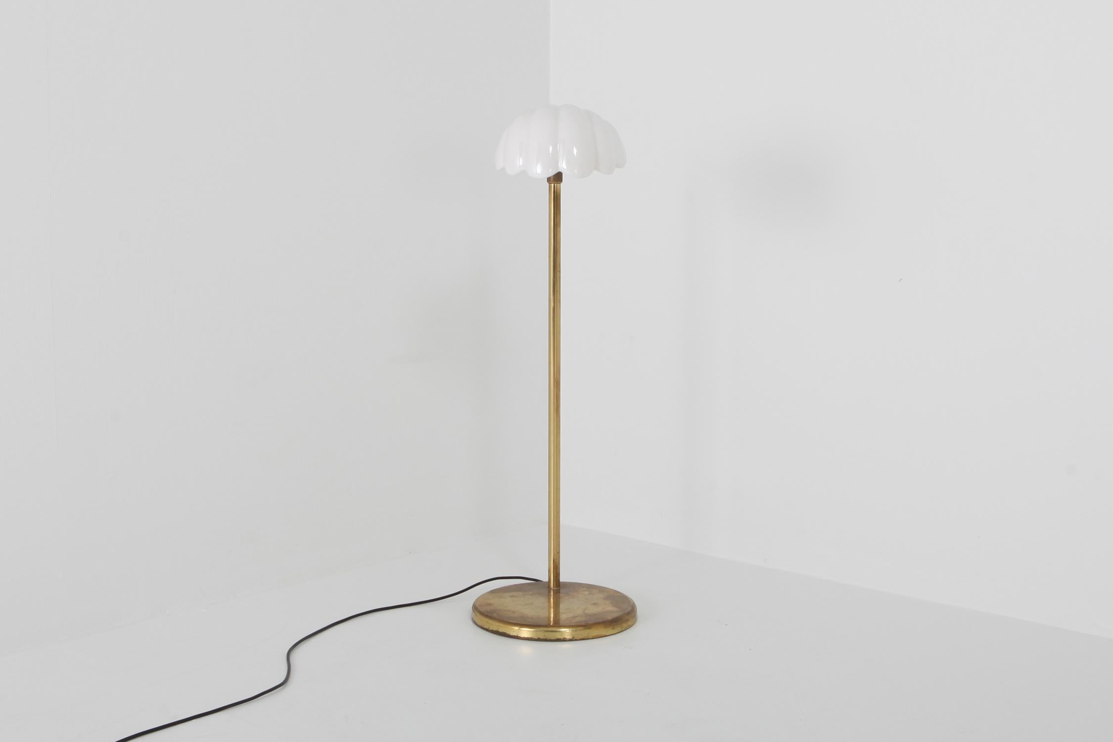 Brass floor lamp, porcelain shade, Angelo Brotto, Italy 1970s
The white porcelain shell shaped hood mounted on an adjustable brass base make this piece into a perfect reading lamp.

Fits well in an eclectic Hollywood Regency inspired by Gabriella