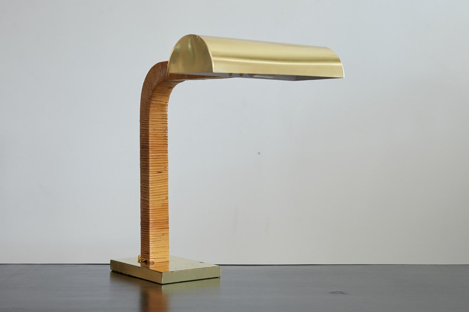 Heavy brass and rattan desk lamp attributed to Paavo Tynell. Heavy brass rectangular base and lamp shade with great patina. Arched neck wrapped in rattan and newly rewired.