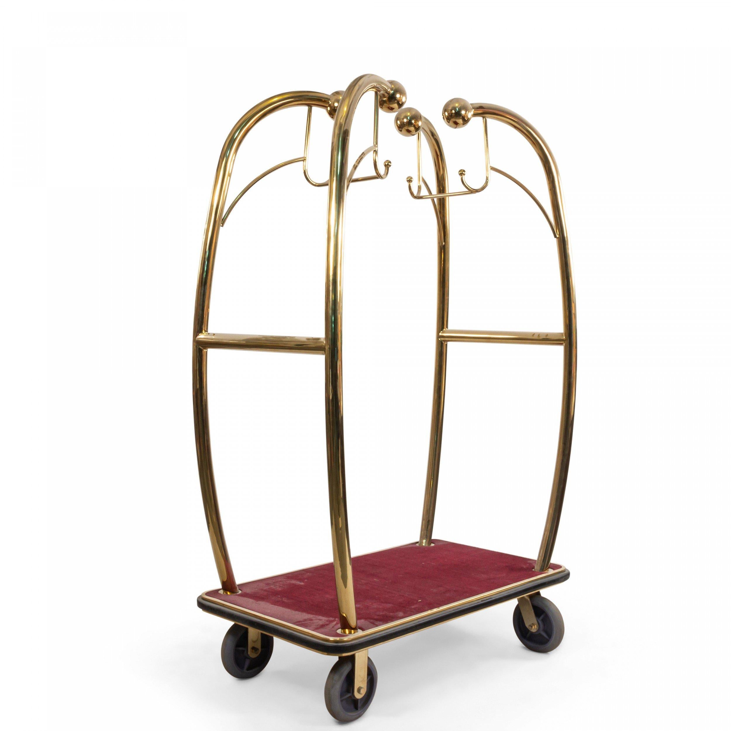 4 mid-century brass hotel bellhop's luggage and hanging garment racks with red carpeted platforms (priced each).
  