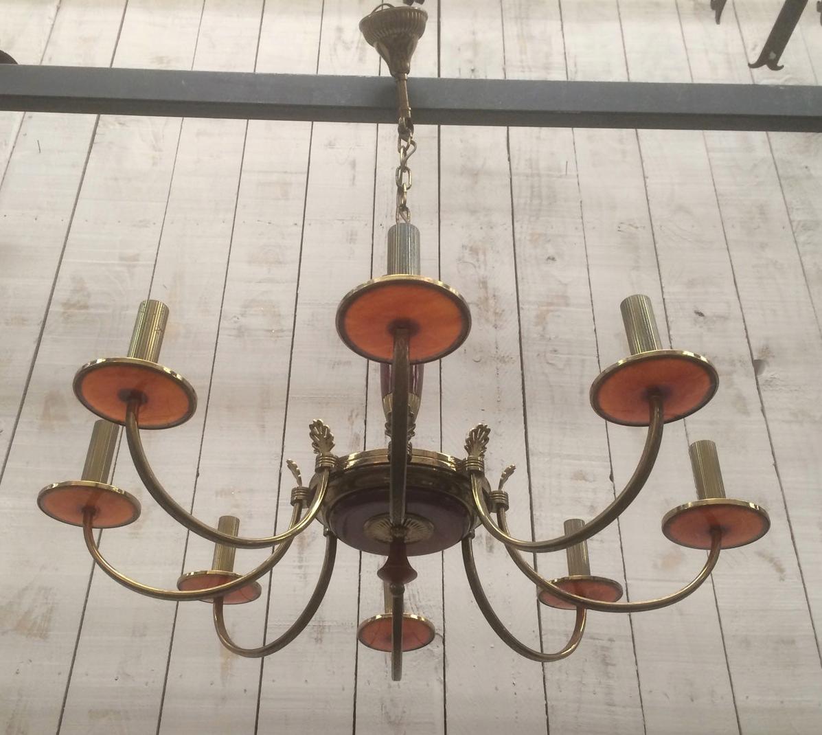 This neoclassical style chandelier is made of brass and red lucite. This is a French work. Circa 1940.