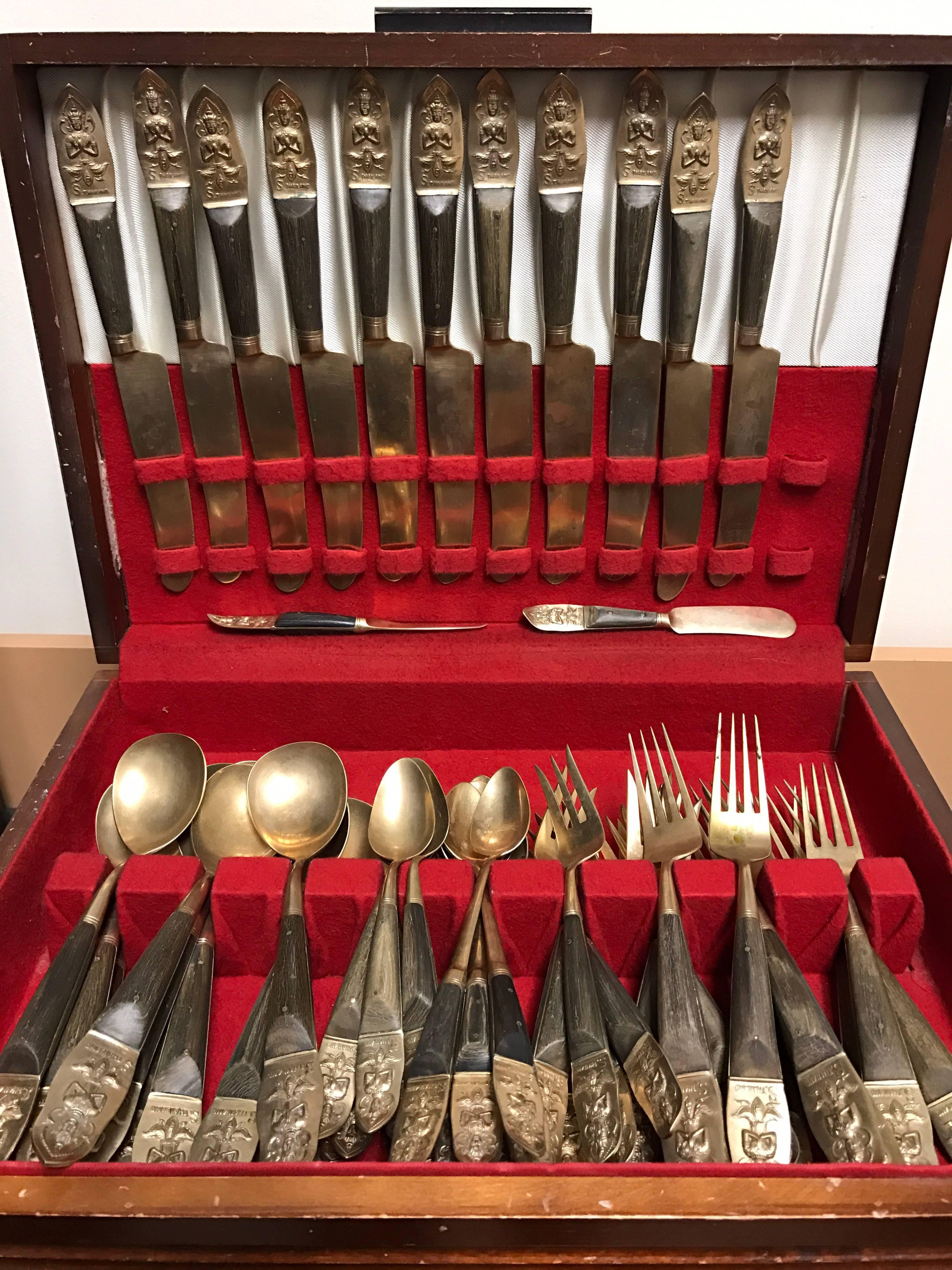 Midcentury Siam 75 pcs, flatware service in original wood box by S. Thailand. All pieces are brass with rosewood handles with cast of seated goddess figure.
11 dinner knives
7 dinner forks
9 salad forks
7 spoons
11 dessert spoons
12 soup spoons
11