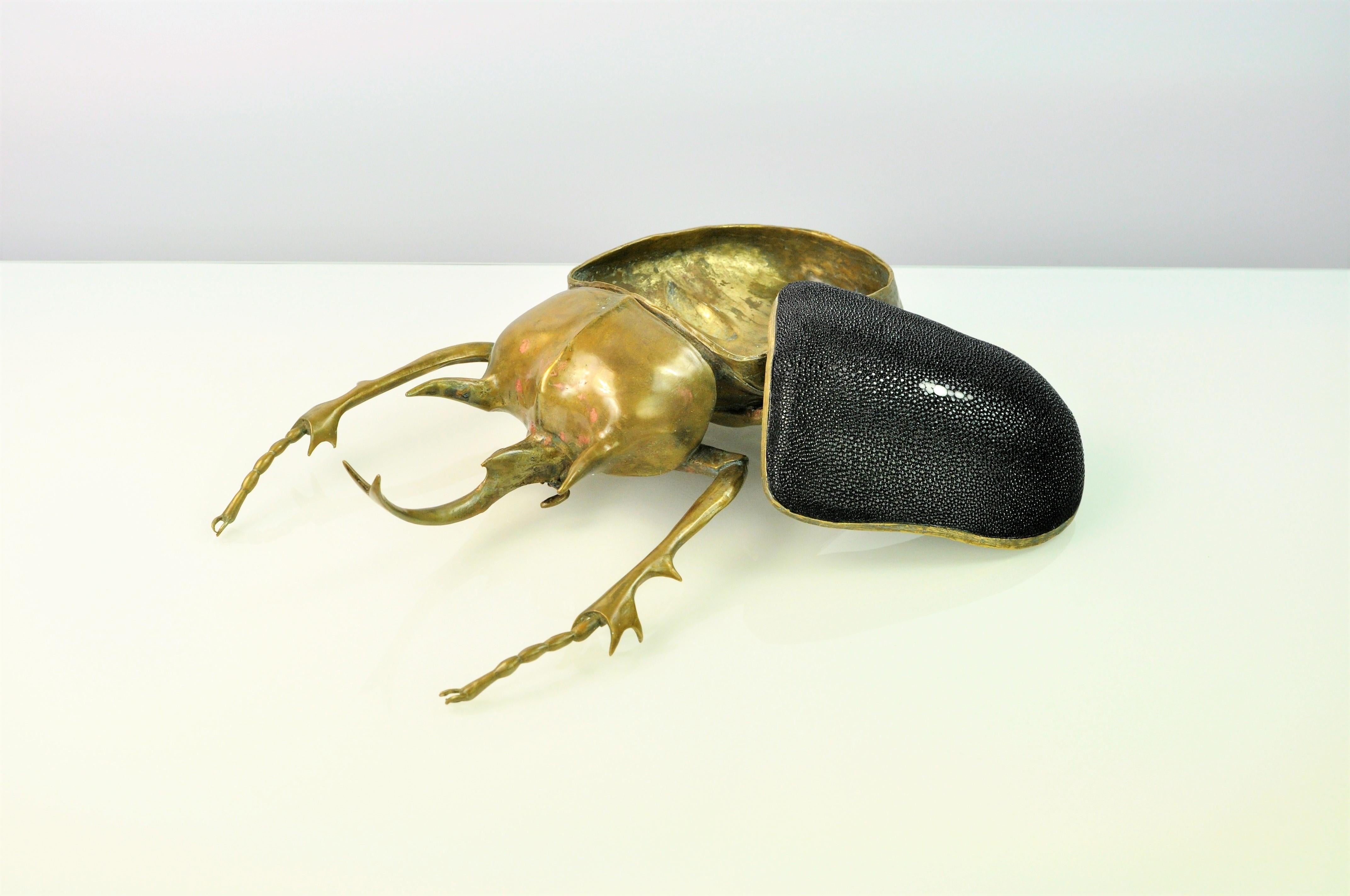 The Elphas Scarab box is a best seller at Ginger Brown.
This piece is made in lost wax cast brass with a bronze patina. The brass lid is covered in shagreen.

That box has been realized from a real scarab. The famous Megasoma actaeon from the family