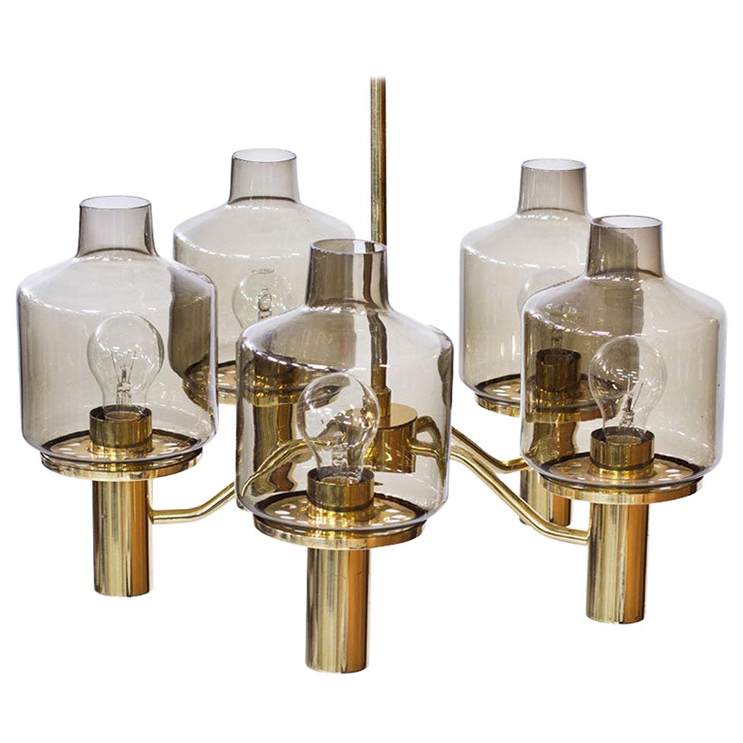 T 507 “PRIOR” chandelier designed by Hans-Agne Jakobsson.
Manufactured by his own company: Hans-Agne Jakobsson AB in Markaryd, Sweden during the 1960s. Polished brass frame, features five lantern style shades in light smoked color glass.
Labeled