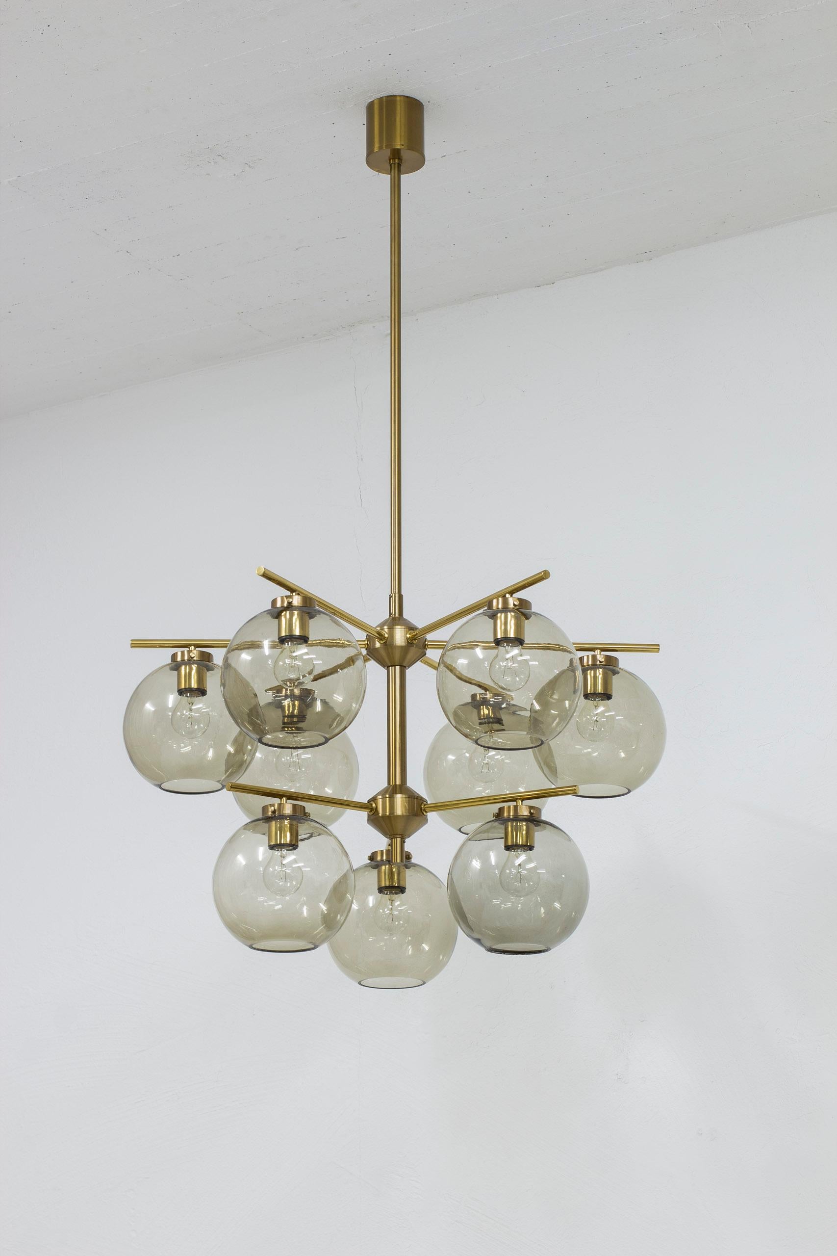 Pair of chandeliers by Holger Johansson. produced in Sweden by Westal during the 1960s. Made from brass with nine smoke glass spheres. Very good vintage condition with light age related wear. Note that there are very minor chips on the glass where