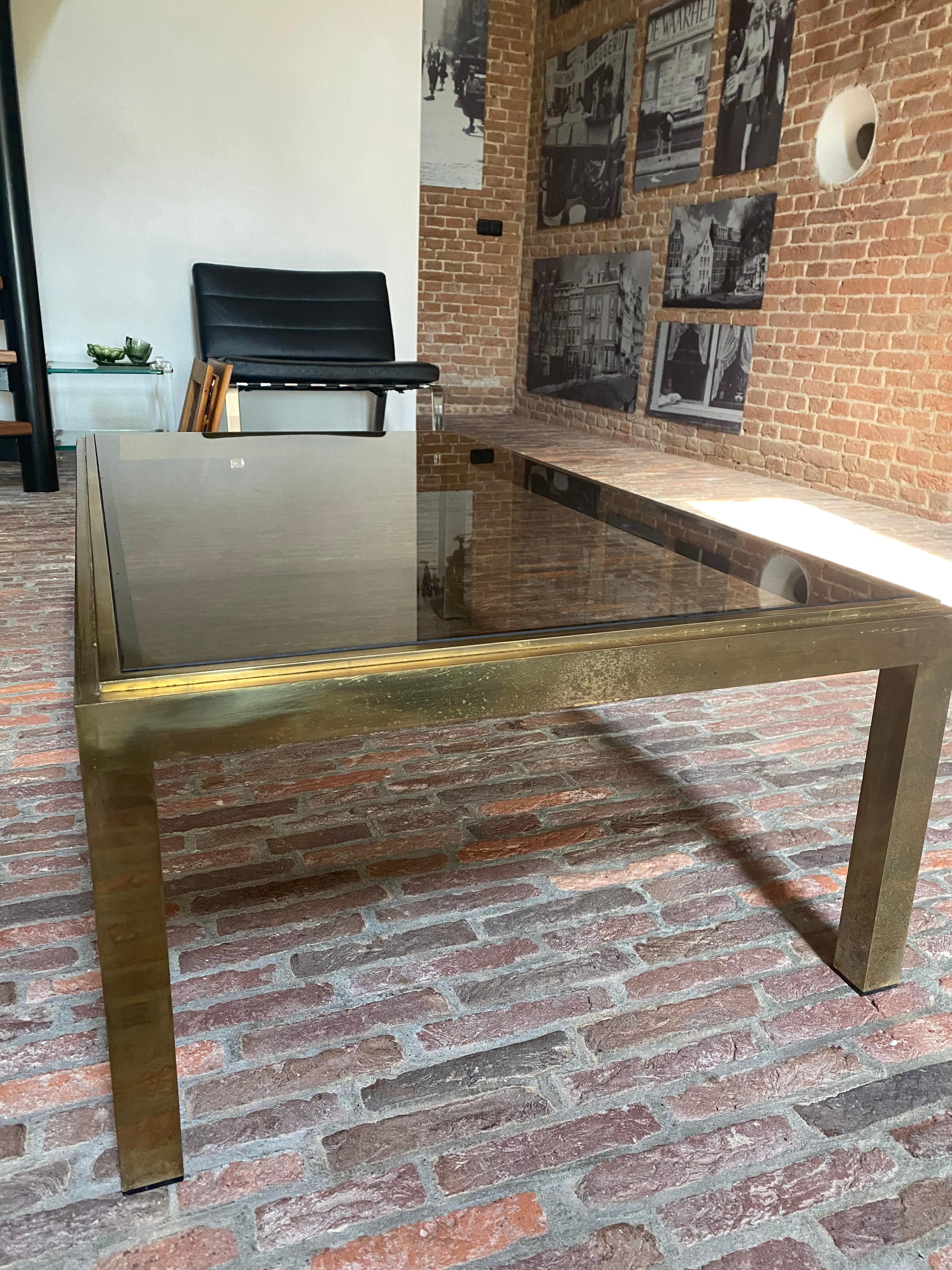 Elegant French Mid-Century Modern coffee table in solid brass with smoked glass top designed attributed to Willy Rizzo. The table is in used condition and has a beautiful patina (small scratches on the brass and glass)
Dimensions: 116 x 66 x 36 cm