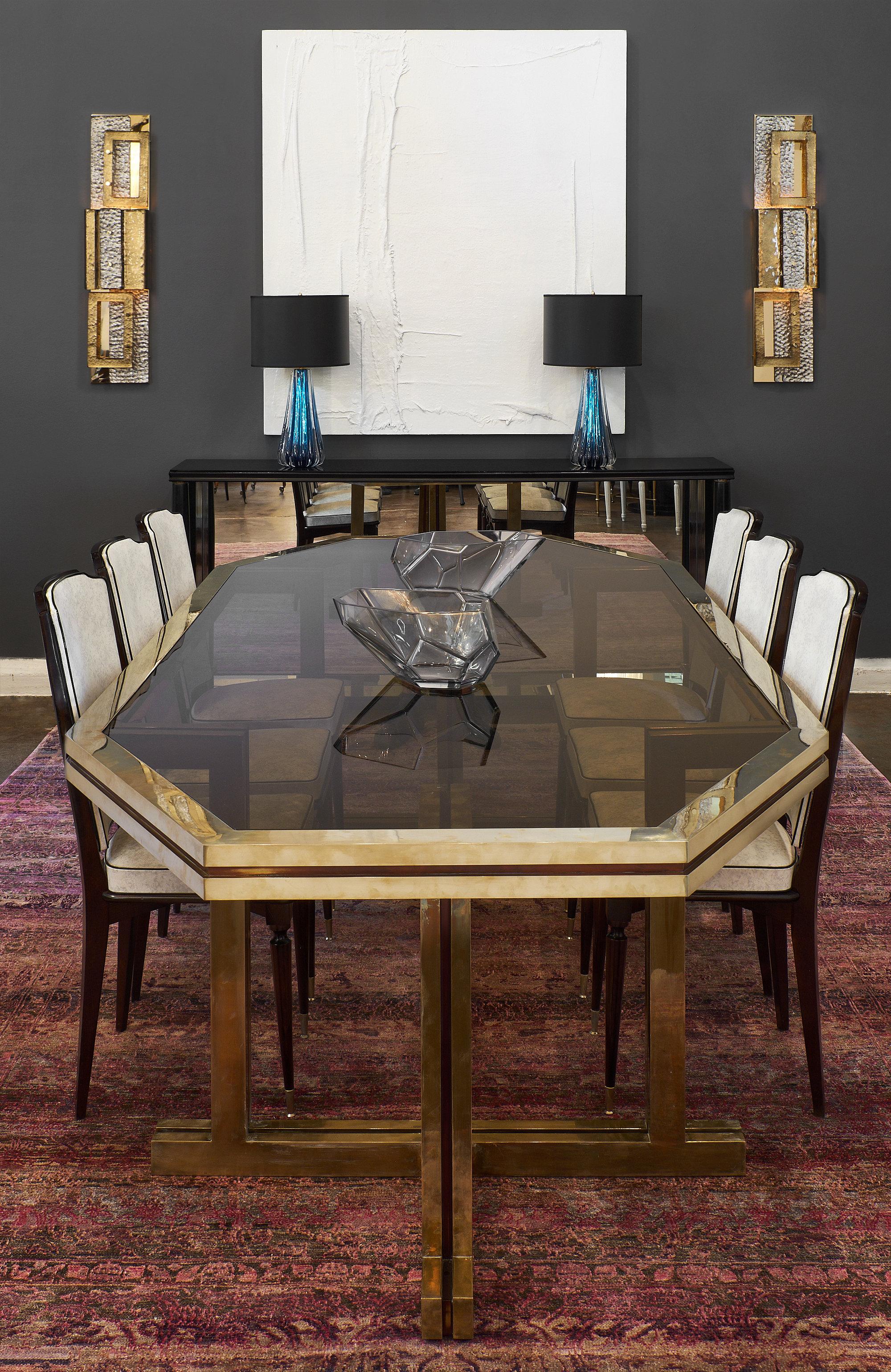 An important and rare Romeo Rega brass and smoked glass dining table. This substantial piece is made of solid brass with the original smoked glass top. We love the strong proportions, and impact of this excellent table!