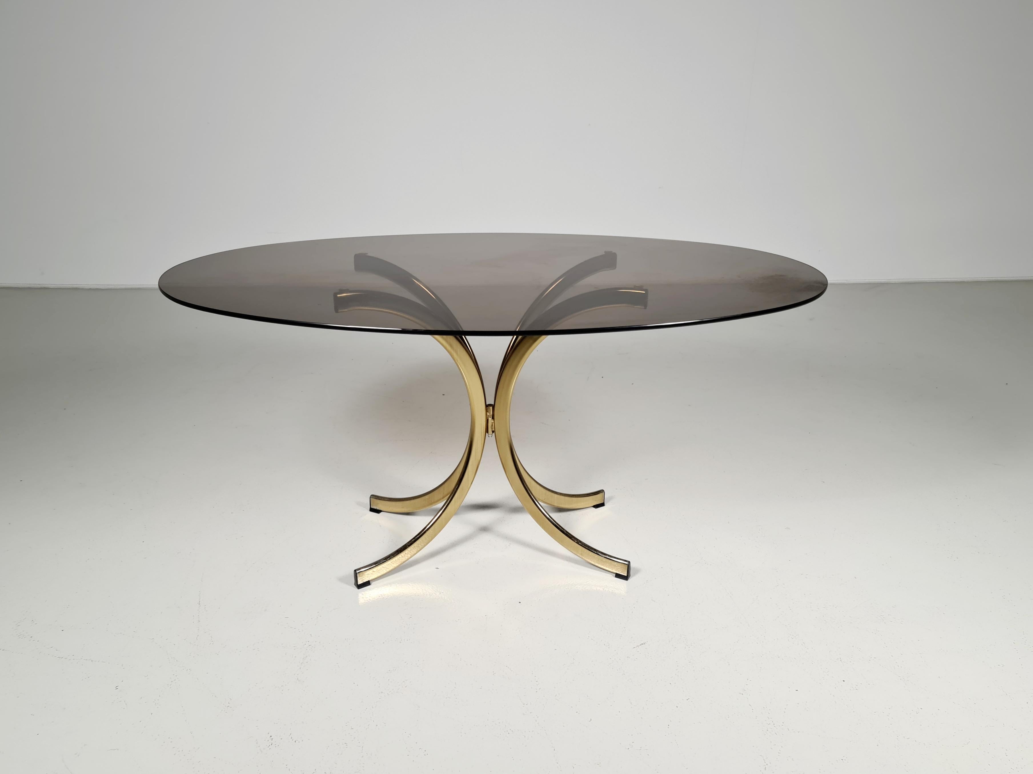 Vintage brass oval dining table with a smoked glass plate. The table is from the 1970s. the brass base with some beautiful patina, glass plate minor wear. Overall a beautiful condition. The design is attributed to Romeo Rega or Paolo Buffa, a very