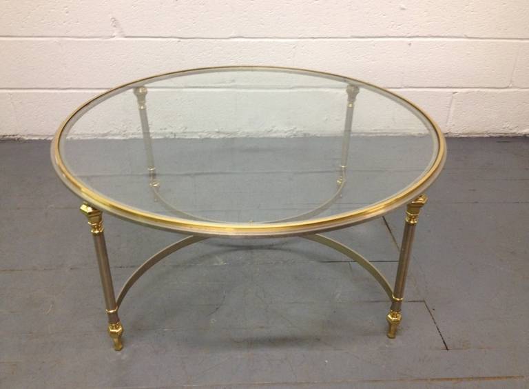 Round, brass and steel coffee table in Maison Jansen style with glass top.