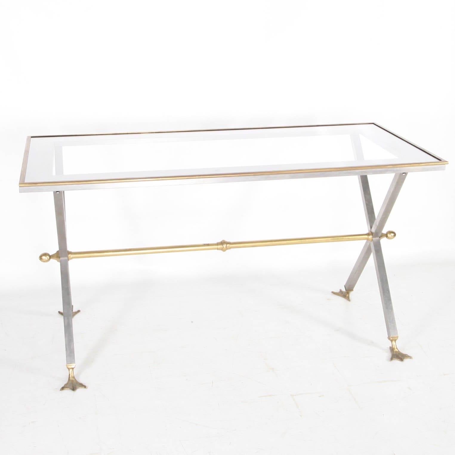Rara scrivania/tavolo in acciaio inossidabile e ottone degli anni Settanta nello stile della Maison Jansen. 
Piano in vetro e gambe a papera.
Ottima qualità e condizione. 