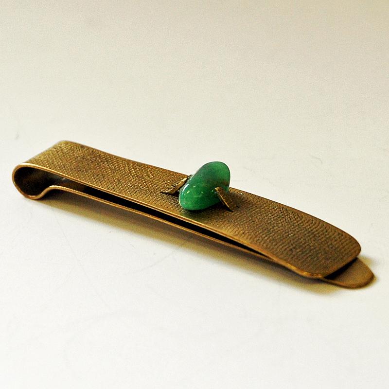 Vintage brass tie pin with a sea green stone on top. Designed in the style of Anna Greta Eker, Norway, 1960s. Rought surface. Scandinavian midcentury design.
Measures: 7.5 cm L x 1.5 cm W. Good vintage condition.