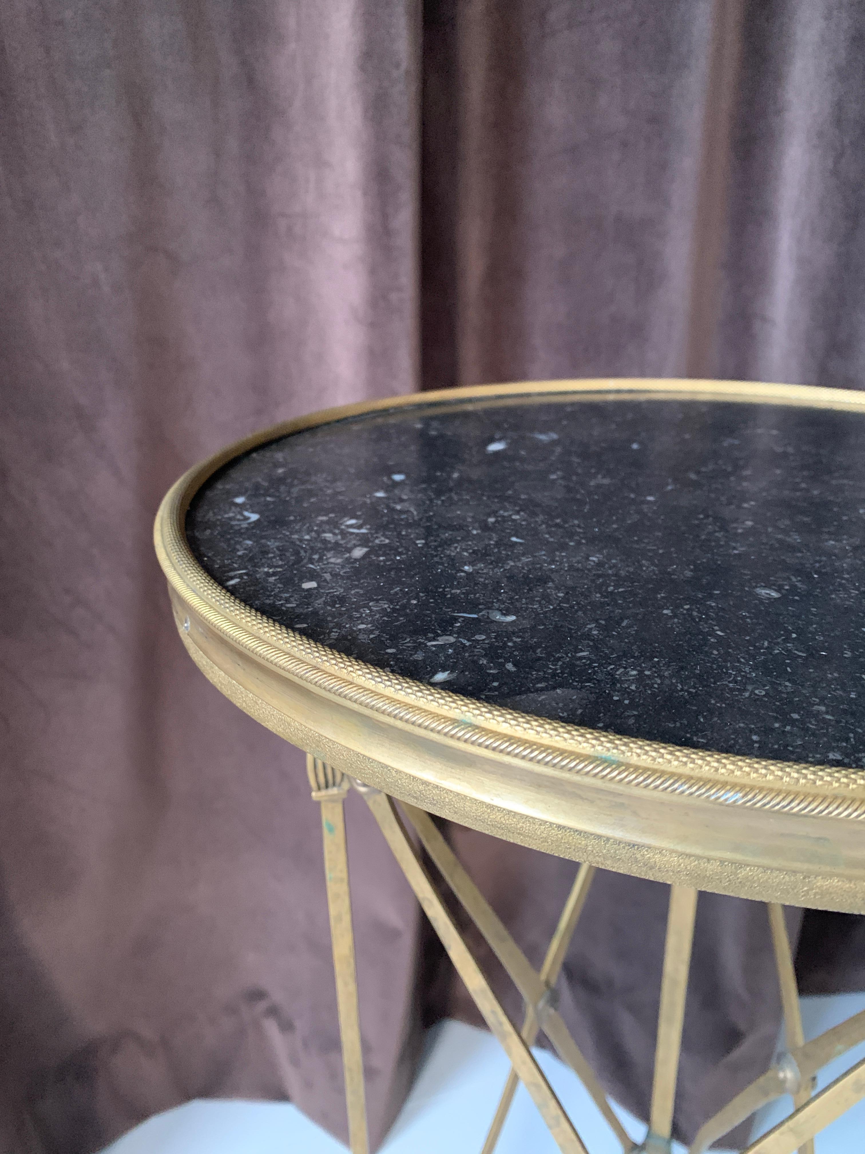 A handsome claw footed brass and black stone neoclassical Guéridon style table.