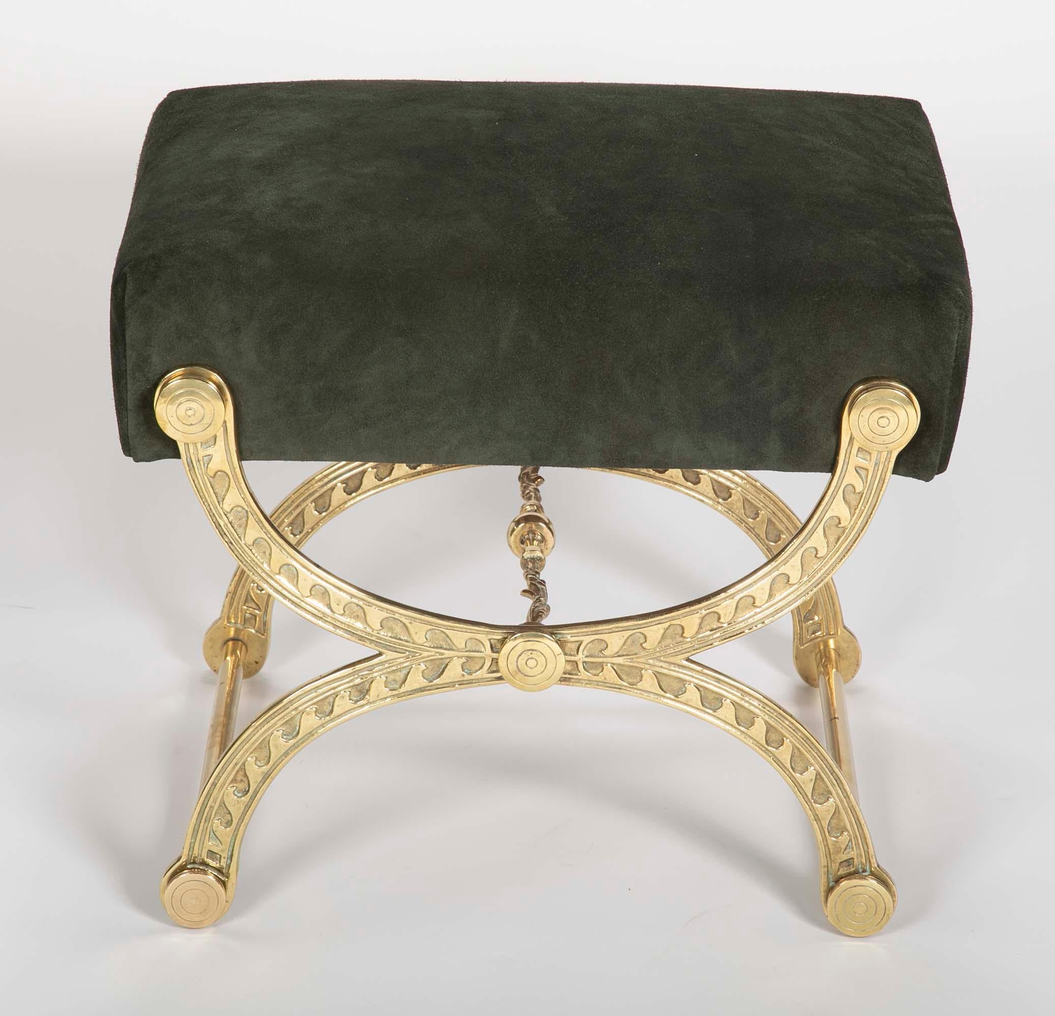 Brass Curule form stool in neoclassical style with Vitruvian wave motif and padded suede seat.