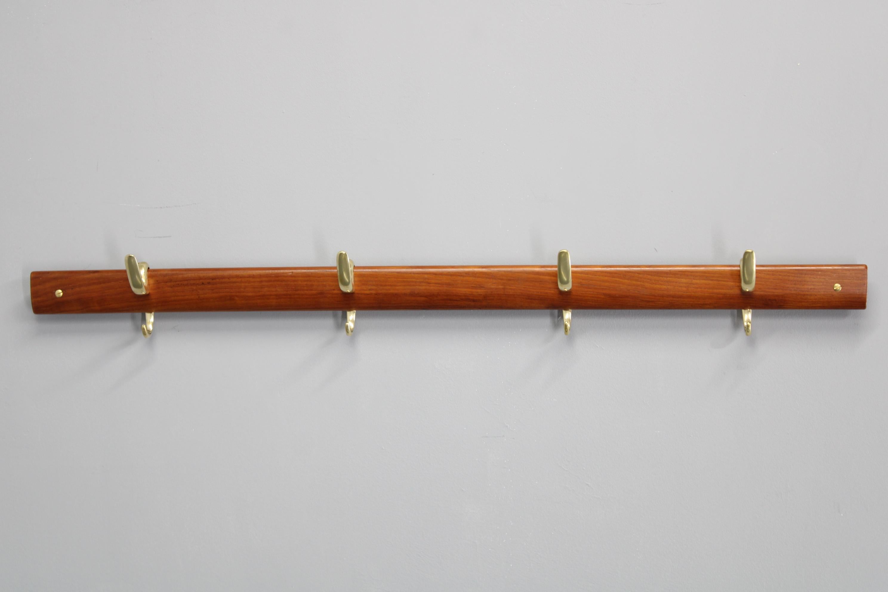  Raro e iconico appendiabiti disegnato da Carl Auböck per Illum Bolighus in Danimarca negli anni '50, che unisce l'elegante minimalismo scandinavo a una raffinata maestria artigianale. Il pezzo è dotato di una barra di montaggio in legno di teak