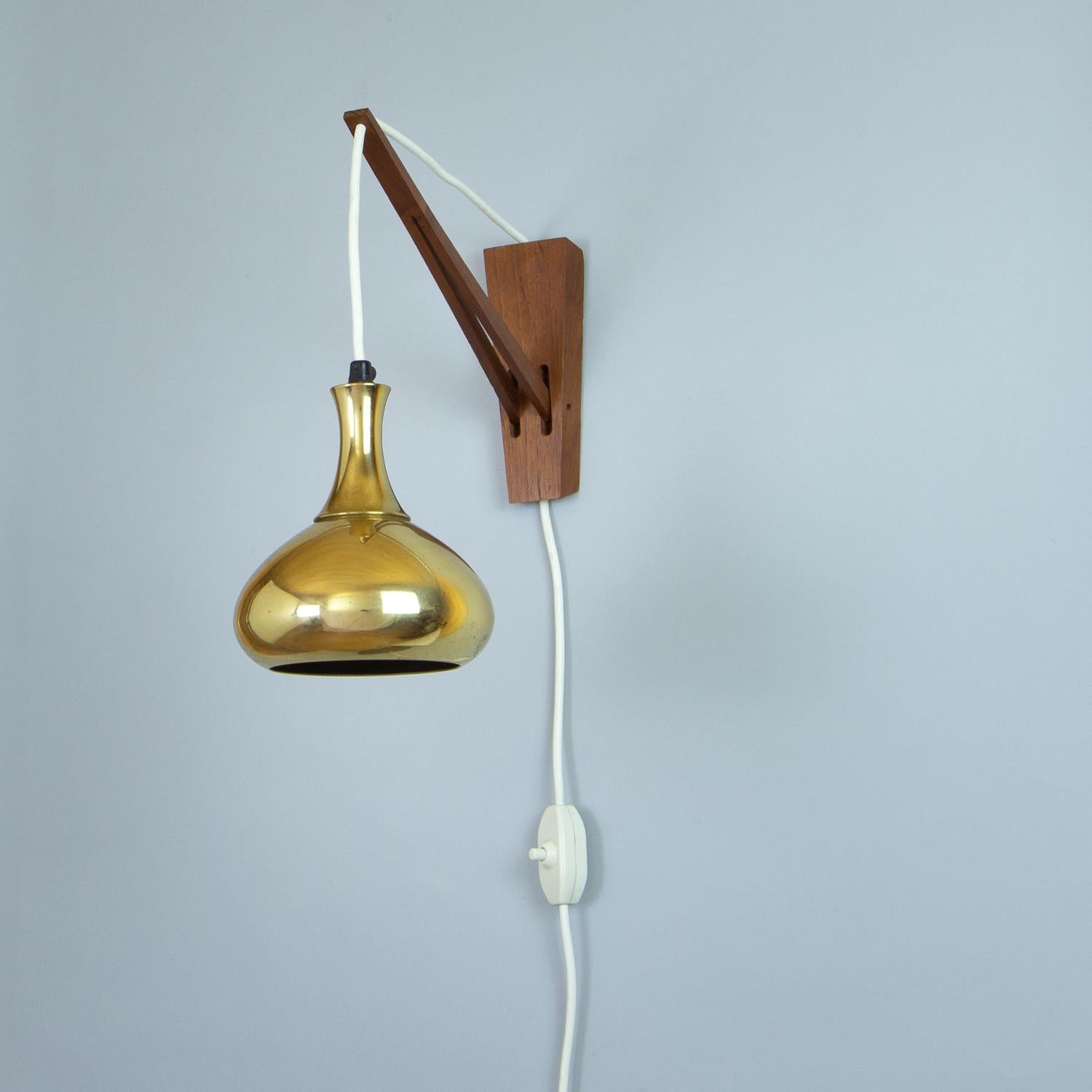 A rare Hans-Agne Jakobsson brass pendant wall light with adjustable teak hanging mechanism. Markaryd AB, Sweden 1960s.