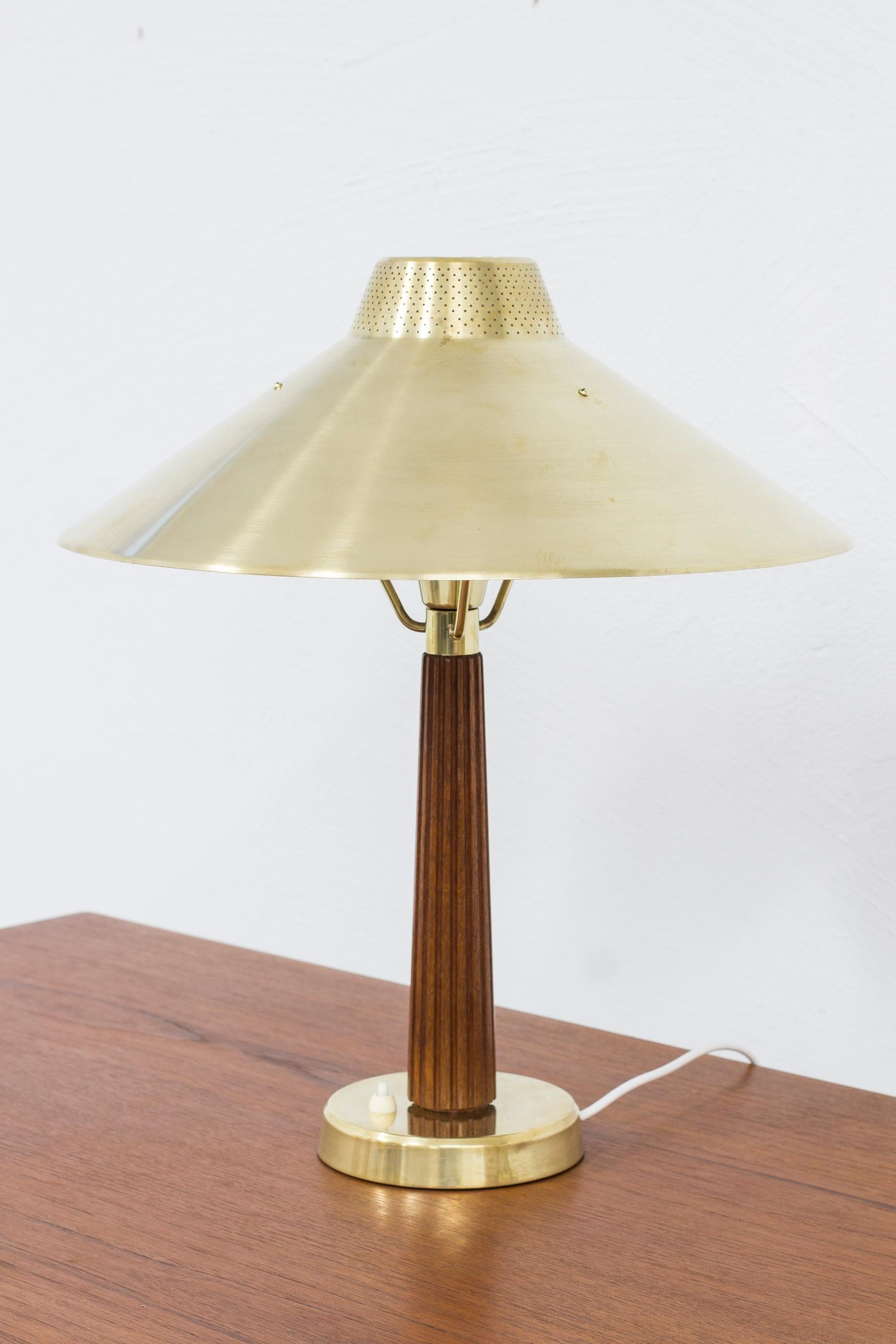 Table lamp model 716 designed by hans Bergström. Produced by Ateljé Lyktan in Åhus Sweden during the 1950s. Made from brass and teak. Light switch on the lamp in working order. Very good vintage condition with few signs of age related wear and