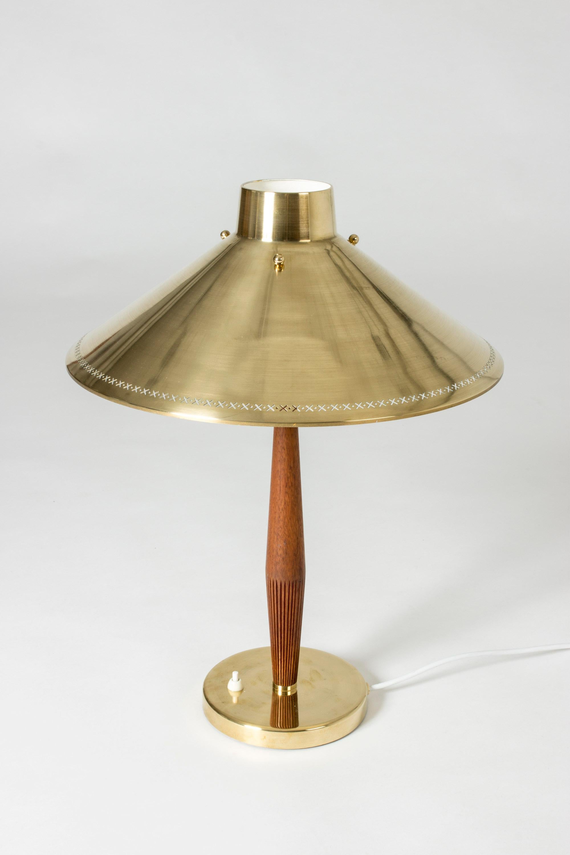 Beautiful table lamp by Hans Bergström for ASEA, with a teak handle with a pattern of carved slits and brass shade with a punched-out pattern around the edge.