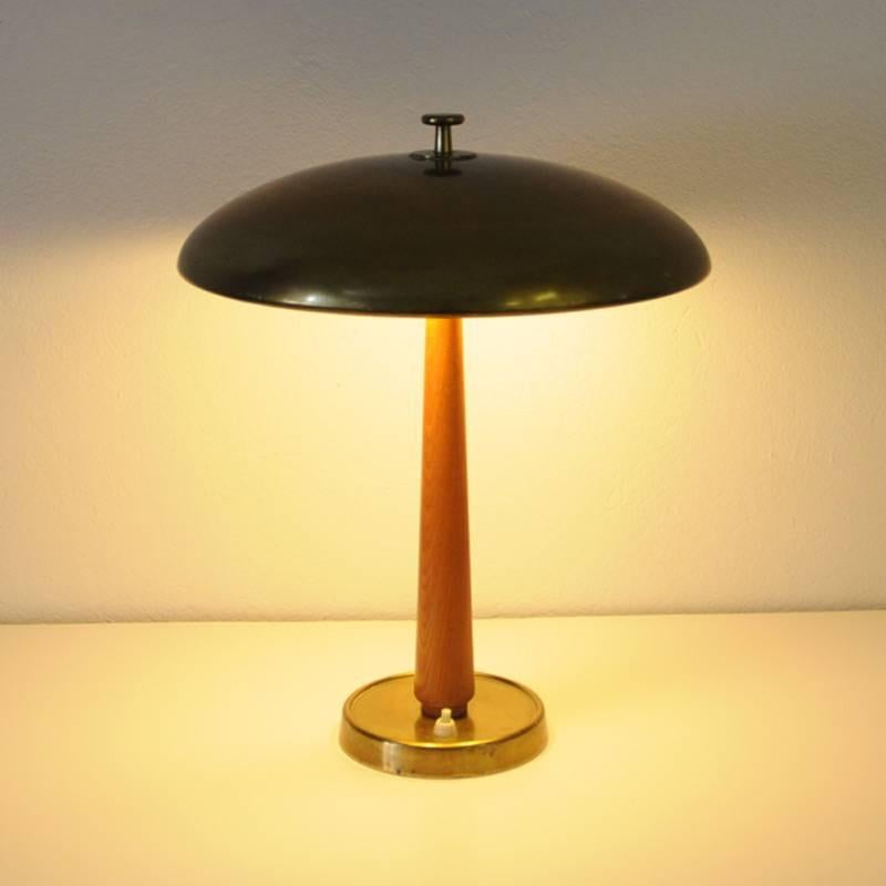 Table lamp with round brass shade and teak pole from around the 1940s. Brass foot base. Two bulbs gives a great and nice shine of light. Measures: 41 cm H, 35 cm D of shade, 14 cm D of base.