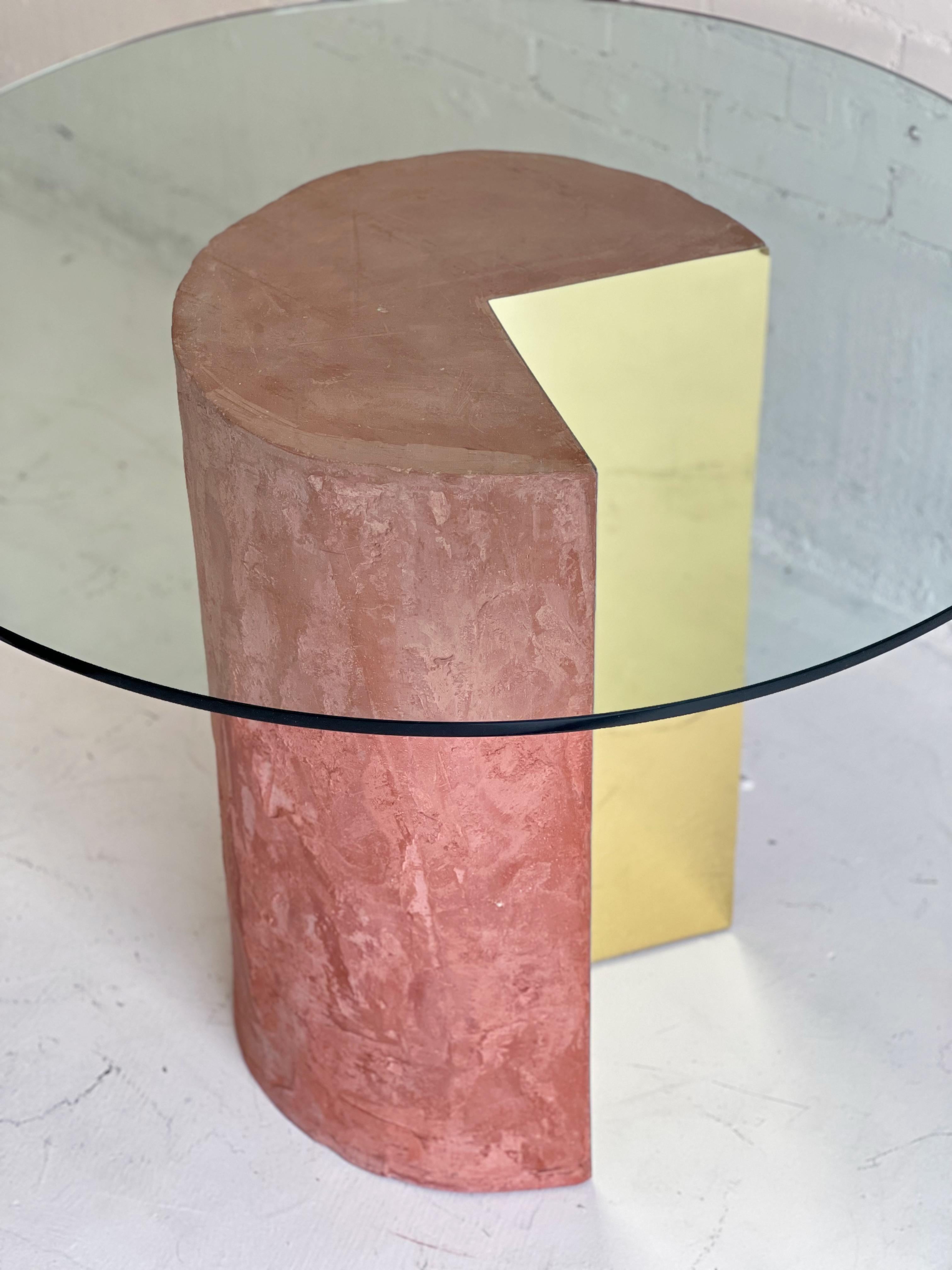 Rich pinkish terracotta and brass dining table after Pace Collection's Pac-Man table c. 1970’s. 

These are typically seen with chrome or brass on the exterior of the cylinder and stone, veneer, or stucco on the interior. This one displays a rare