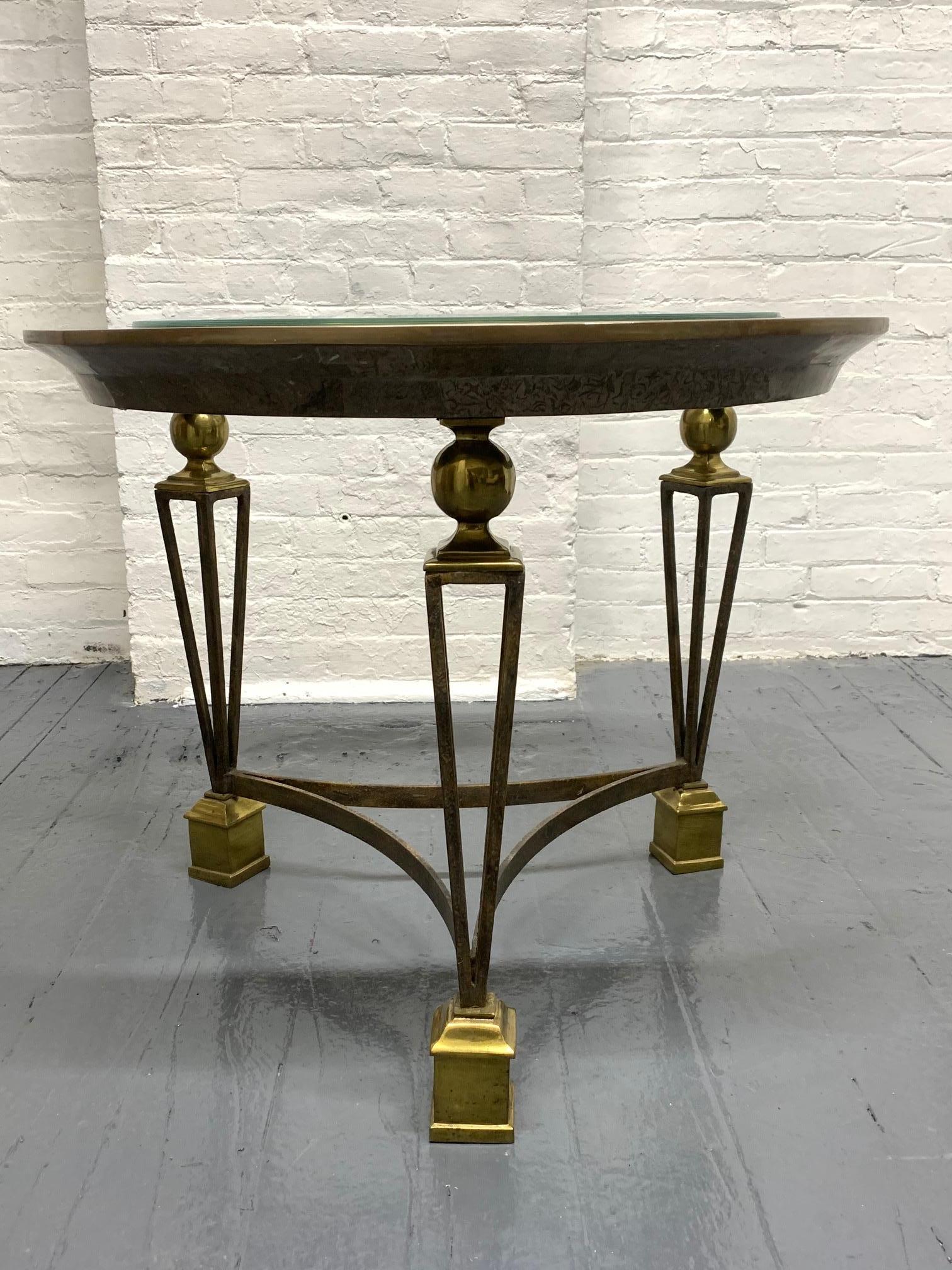 Well designed brass and glass top side table. The outer rim of the table is tessellated stone. Some scratches to the glass. Legs are wrought iron. The feet and round balls on top of the legs are brass. Nice squared feet. Manner of Gilbert Poillerat.