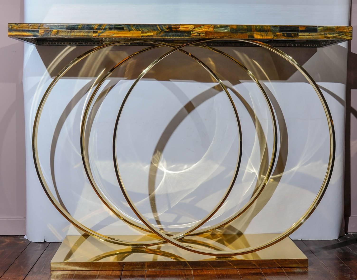 Beautiful console with a foot made with three brass rings, top in tiger eye stone.