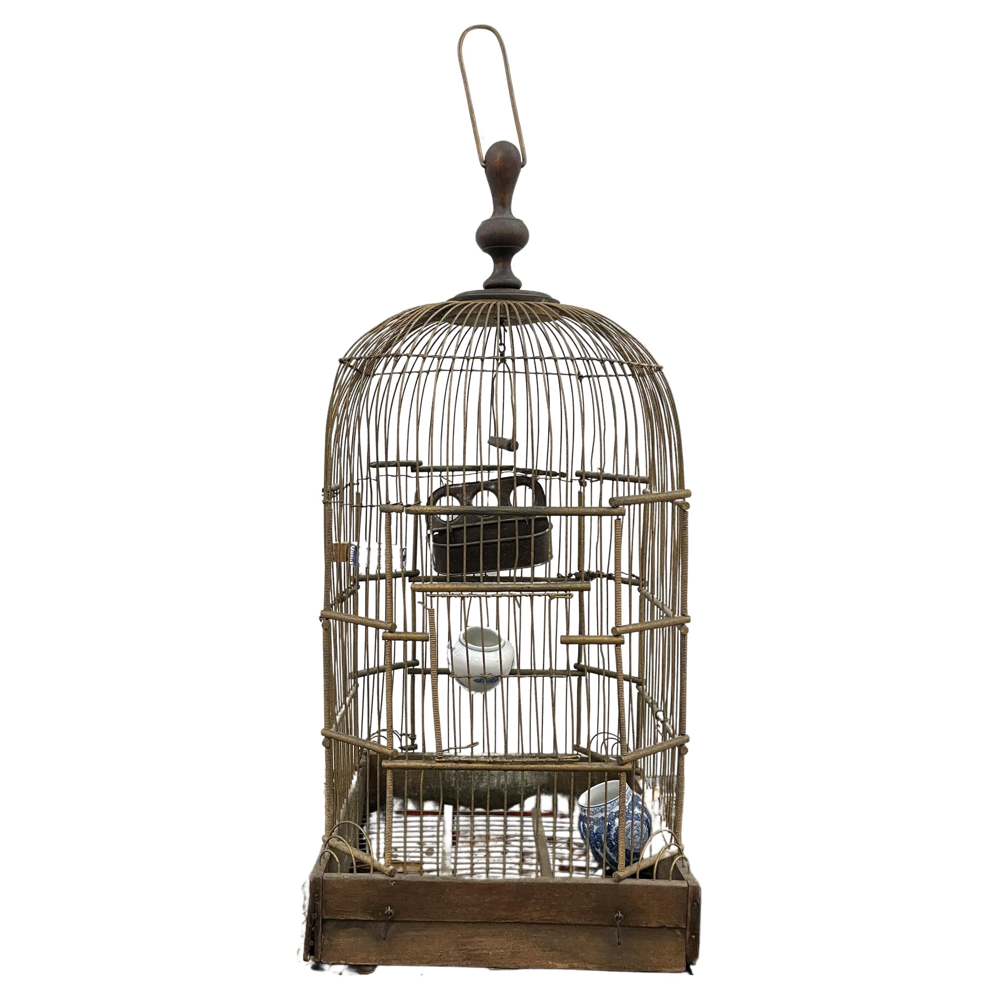 Cage à oiseaux en laiton et bois avec mangeoires en porcelaine circa 1920