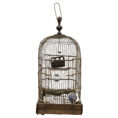 Brass and wood base birdcage with porcelain feeders circa 1920
