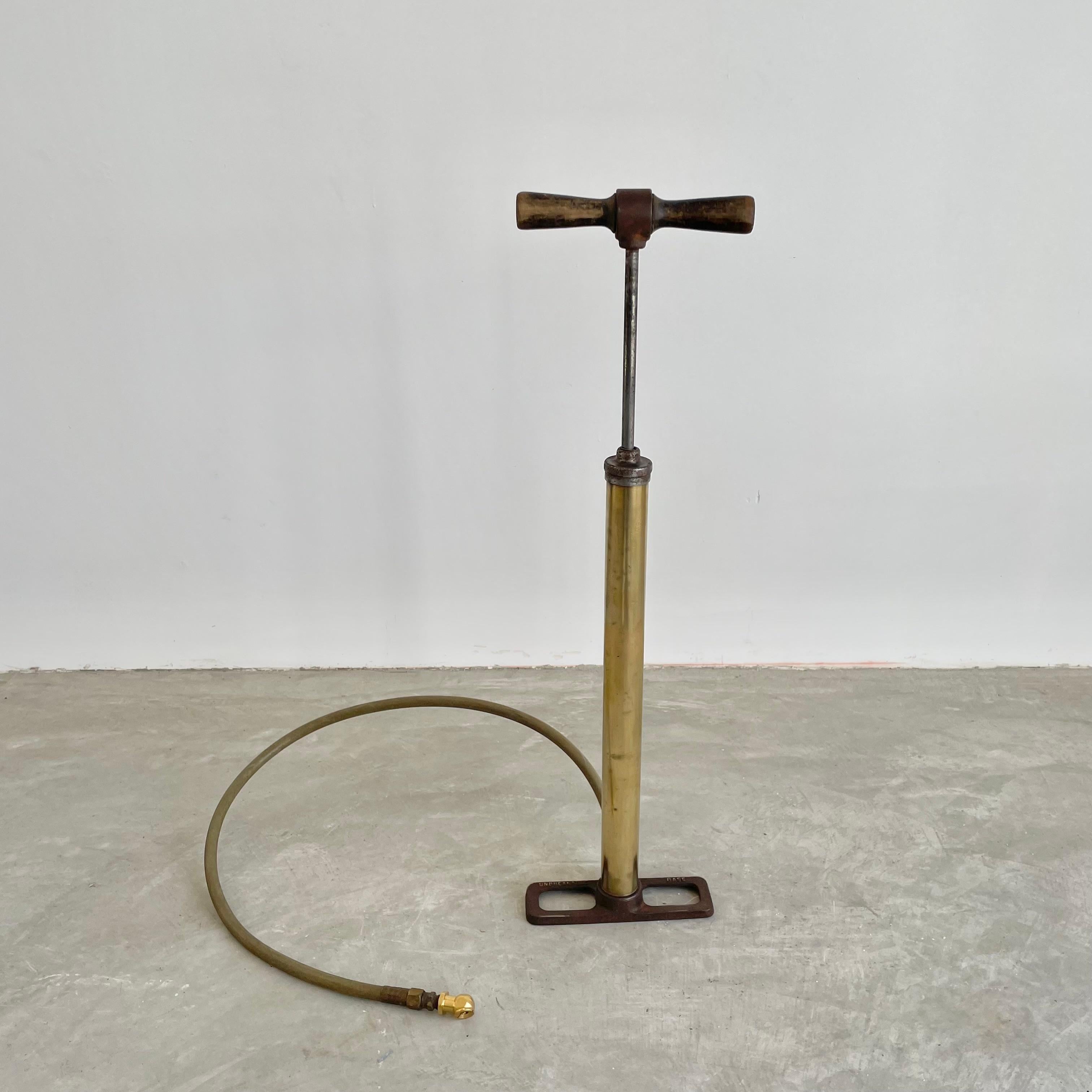 Cool 1930s antiqued brass and wood bike pump with rubber hose. Metal base with 'Unbreakable Base' embossed on the surface. Amazing patina to body and wooden handles. Great for bicycle enthusiasts. Pump blows air but cannot confirm that it will