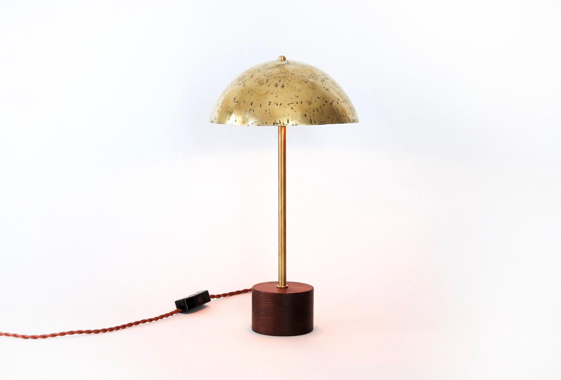 Vera wood and brass table lamp. Hand forged and polished brass shade. Braided 6’ cord. Takes two S14 lightbulbs.

This design, affectionately referred to as the 