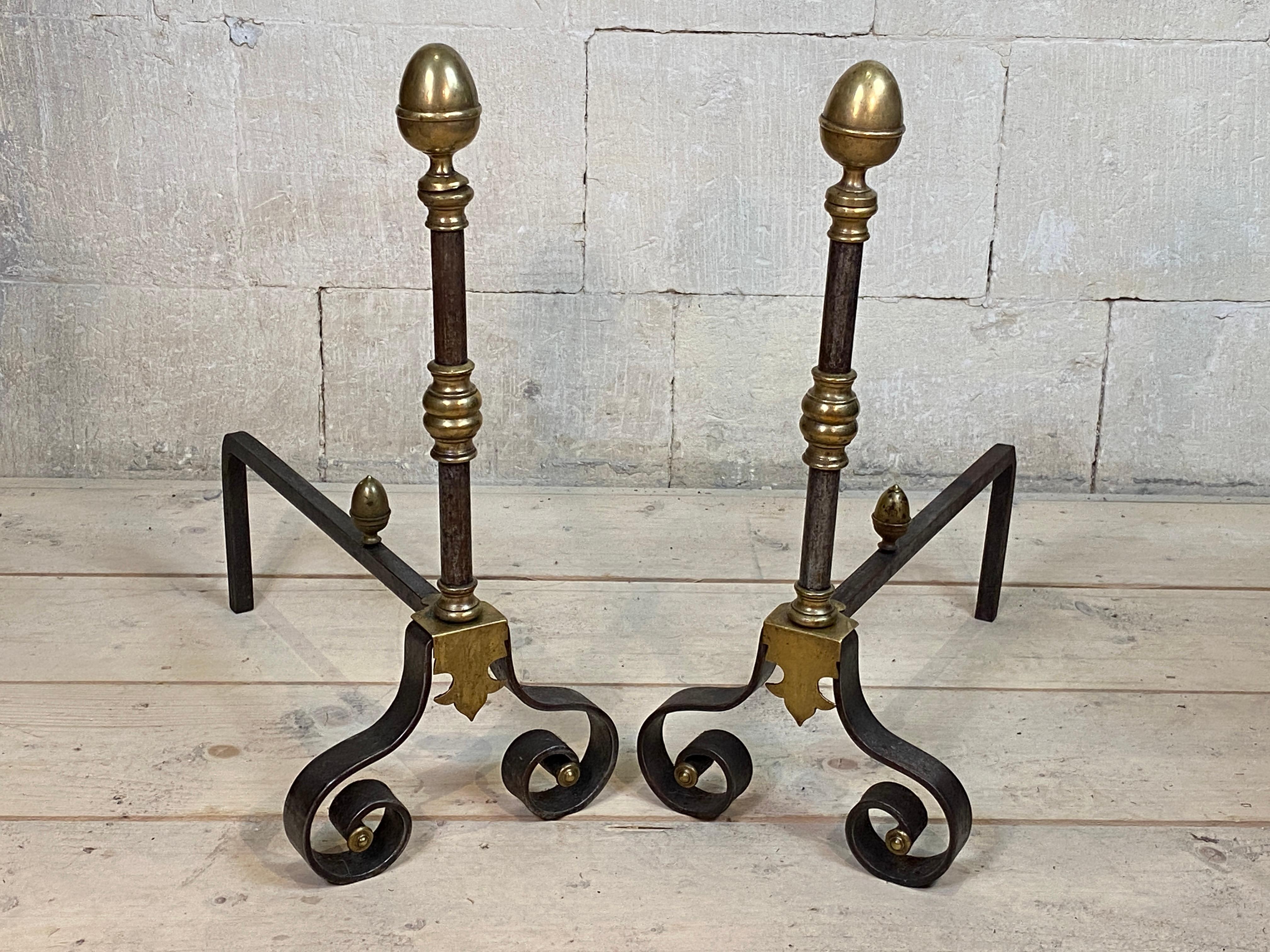 Brass Andirons Firedogs Burnished steel Acorn Finials French 

A pair of iron and brass andirons with sectioned brass turnings and turned acorn finials on each with scrolled feet bases.
  

 