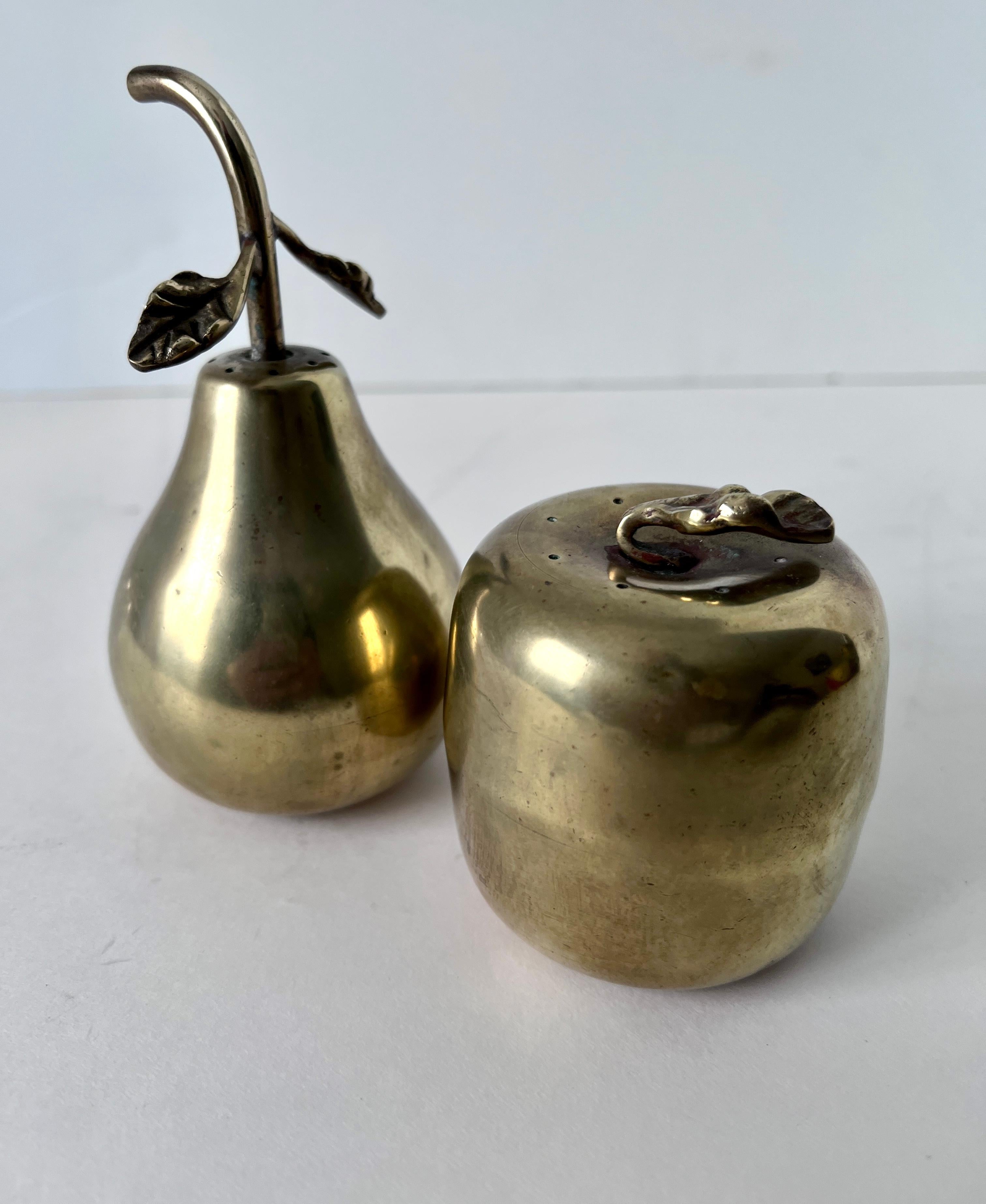 A lovely pari of salt and pepper shakers in the shape of a pear and an apple... the pair are a compliment to any table and wonderful at the holidays. 

The leaves unscrew for adding your spices.