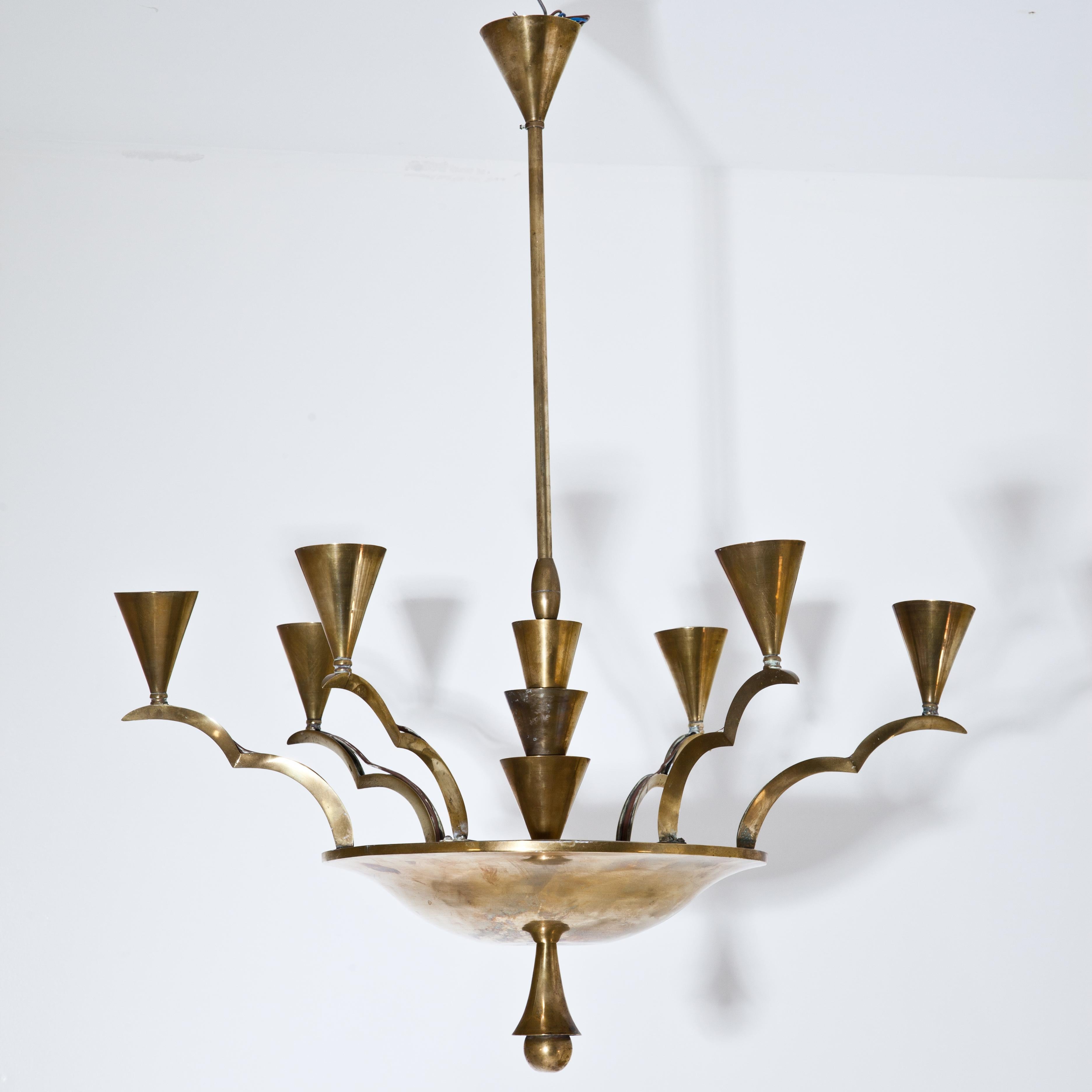 Chandelier in the style of Dagobert Peche made of brass with wavy scalloped arms with six sockets and a round bowl with cone and ball ornaments well as other conical elements around the slender rod.
For the electrification we assume no liability