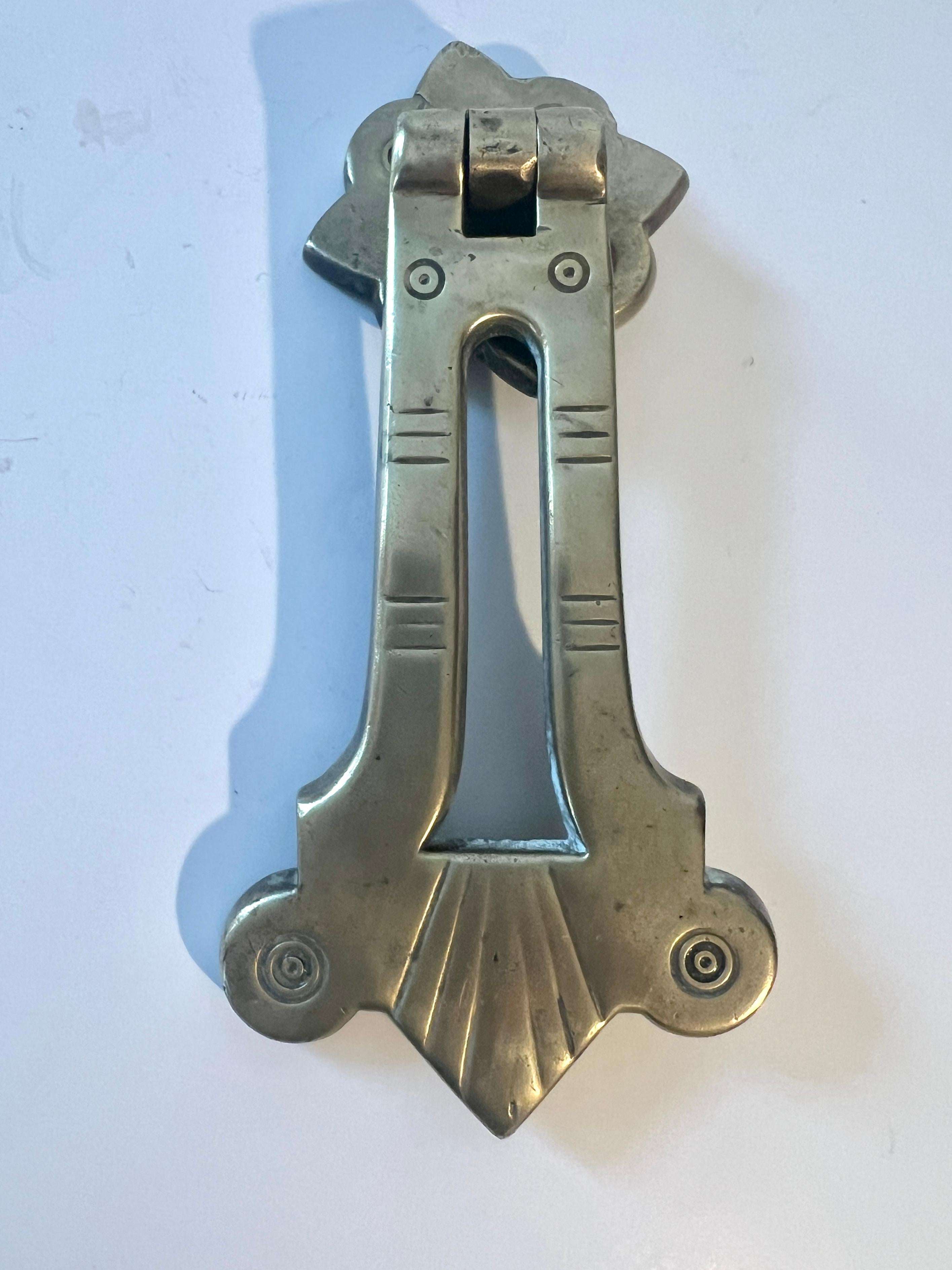 Un bellissimo battente in ottone Art Deco.  Il battente è un delizioso esempio del design semplice ma affascinante del periodo Art Deco dei primi del Novecento.

Questo battente parla della famiglia che vive al di là di esso: è un esempio
