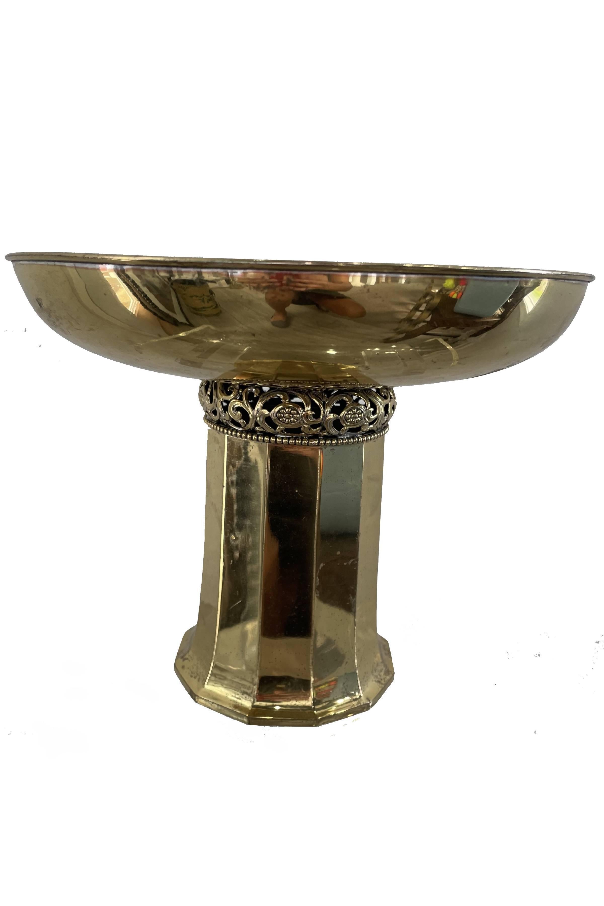 This stunning brass footed bowl, with its clean lines, is bifurcated at the neck by detailed filigree. It is lovely by itself, filled with decorative items or as a fruit bowl.