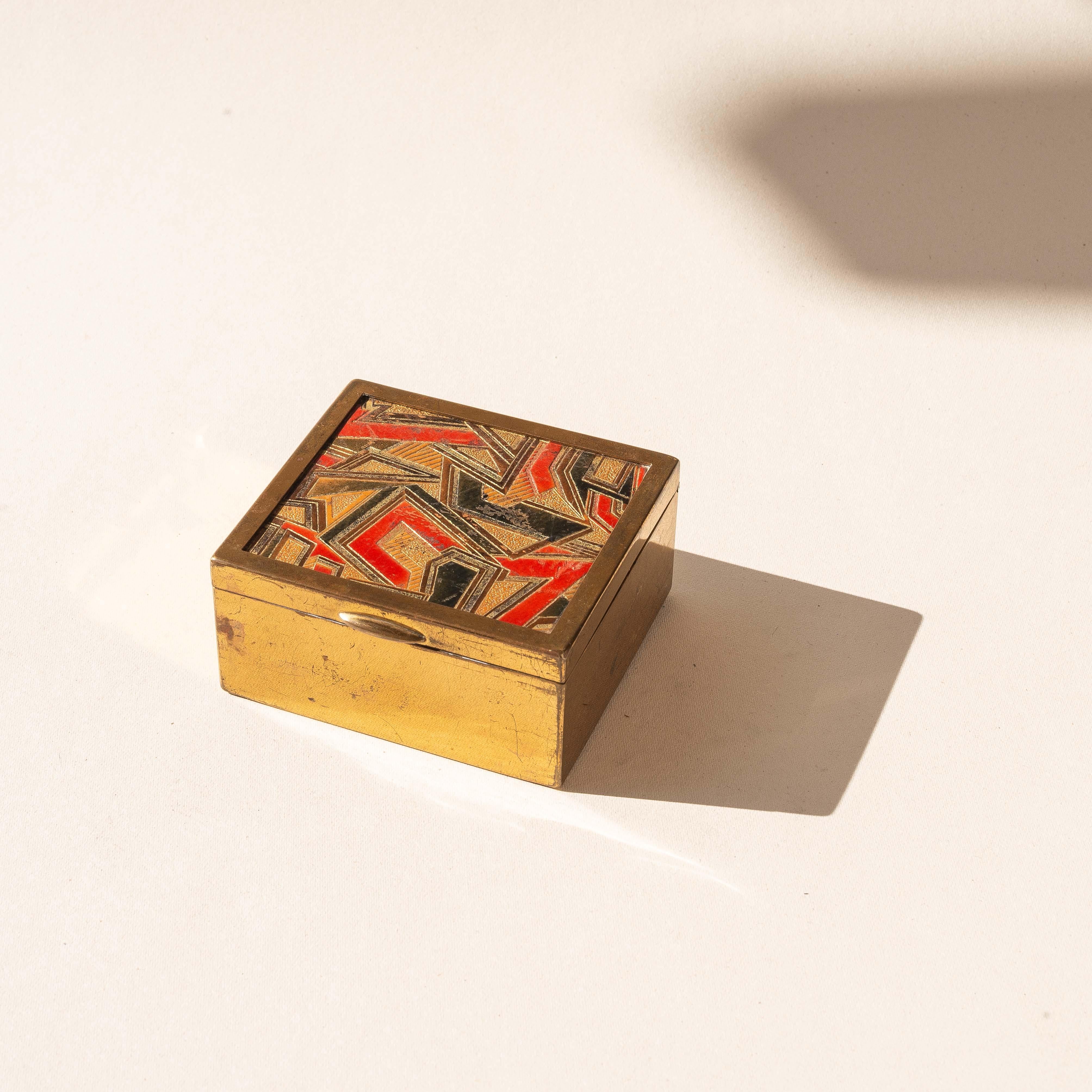 Schmuckkästchen oder Deko-Schmuckkästchen aus Messing im Art déco-Stil, farbenfrohe Ledereinlage, Frankreich

Vom Art Deco inspirierte Schachtel aus Messing und Leder.

Der Deckel weist eine bunte und grafische Ledereinlage in Rot-, Schwarz- und