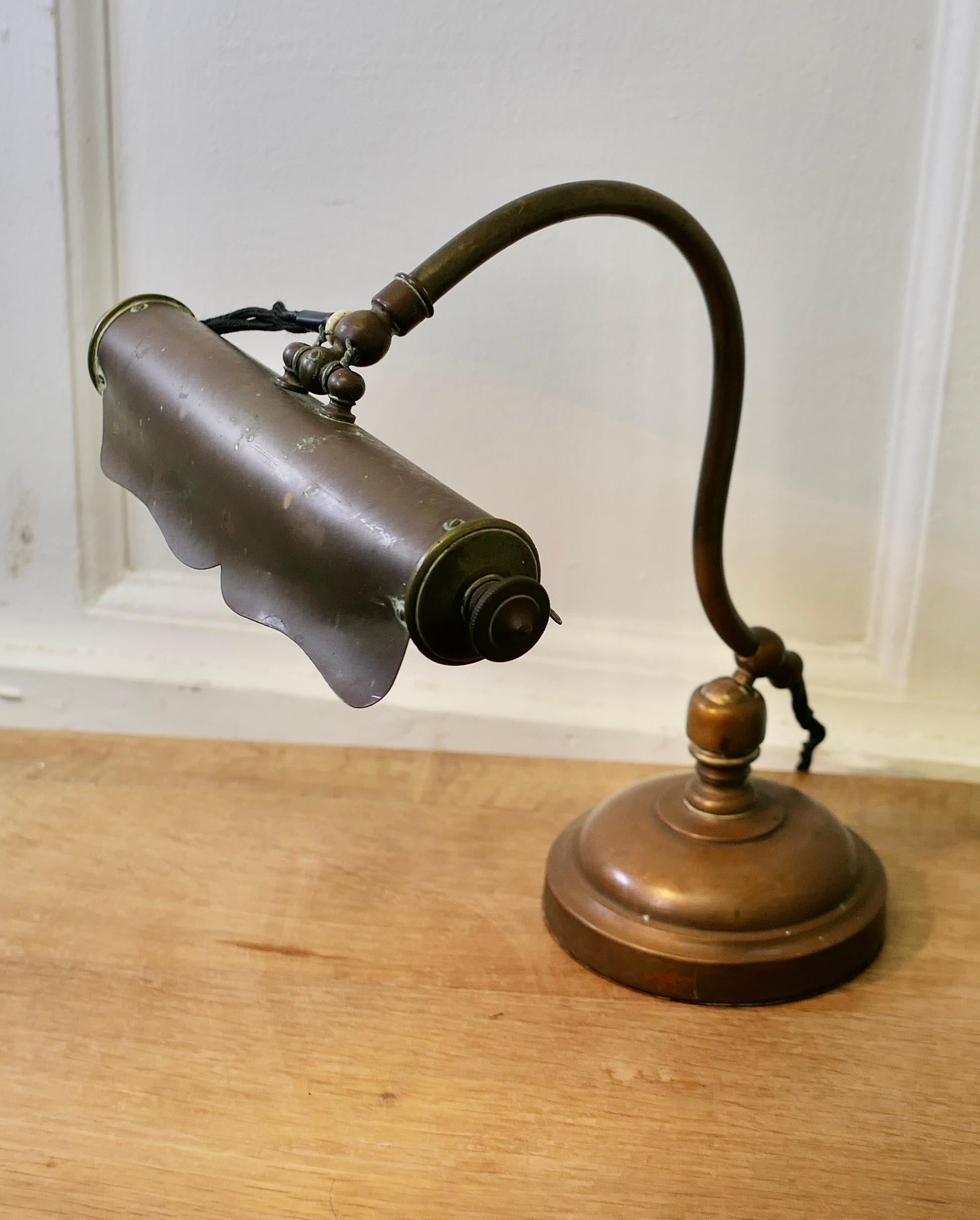 Brass Art Nouveau Adjustable Library Lamp 

This is a very unusual piece, the lamp has a round brass base which supports the swivelling swan neck arm, this in turn supports the long cylindrical lamp which also swings up and down to adjust the