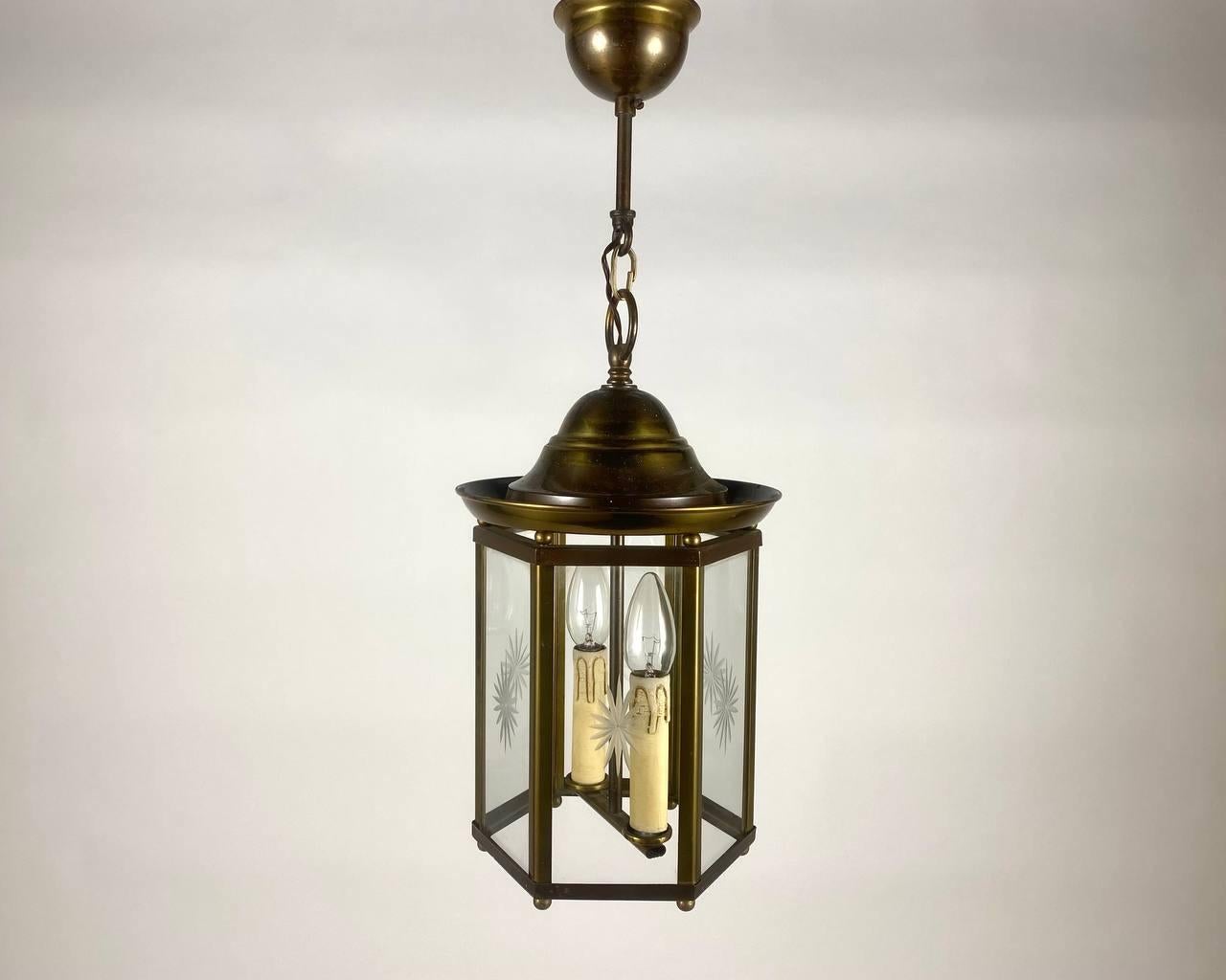 Lustre artisanal vintage - lanterne pour deux points lumineux fabriqué dans les années 1980. 

La lanterne de plafond est une combinaison étonnante de la garantie du fabricant et du design du luminaire.

L'abat-jour hexagonal est livré avec les