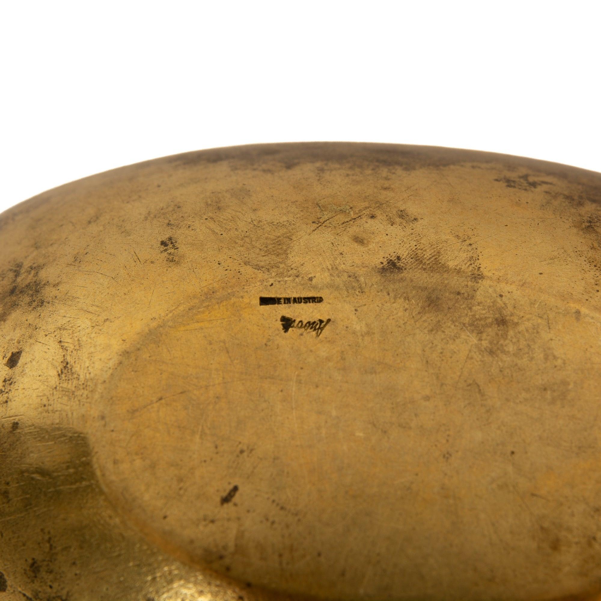 A brass ashtray with rest.