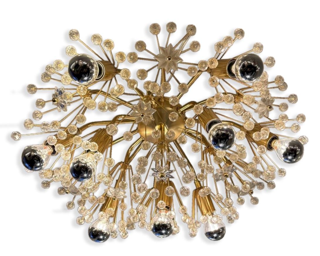 A radiant fusion of mid-century futurism and celestial elegance, this Austrian snowflake sputnik chandelier dazzles with intricate detail and sculptural drama. Dozens of delicate crystal beads and star-shaped prisms burst from a central brass