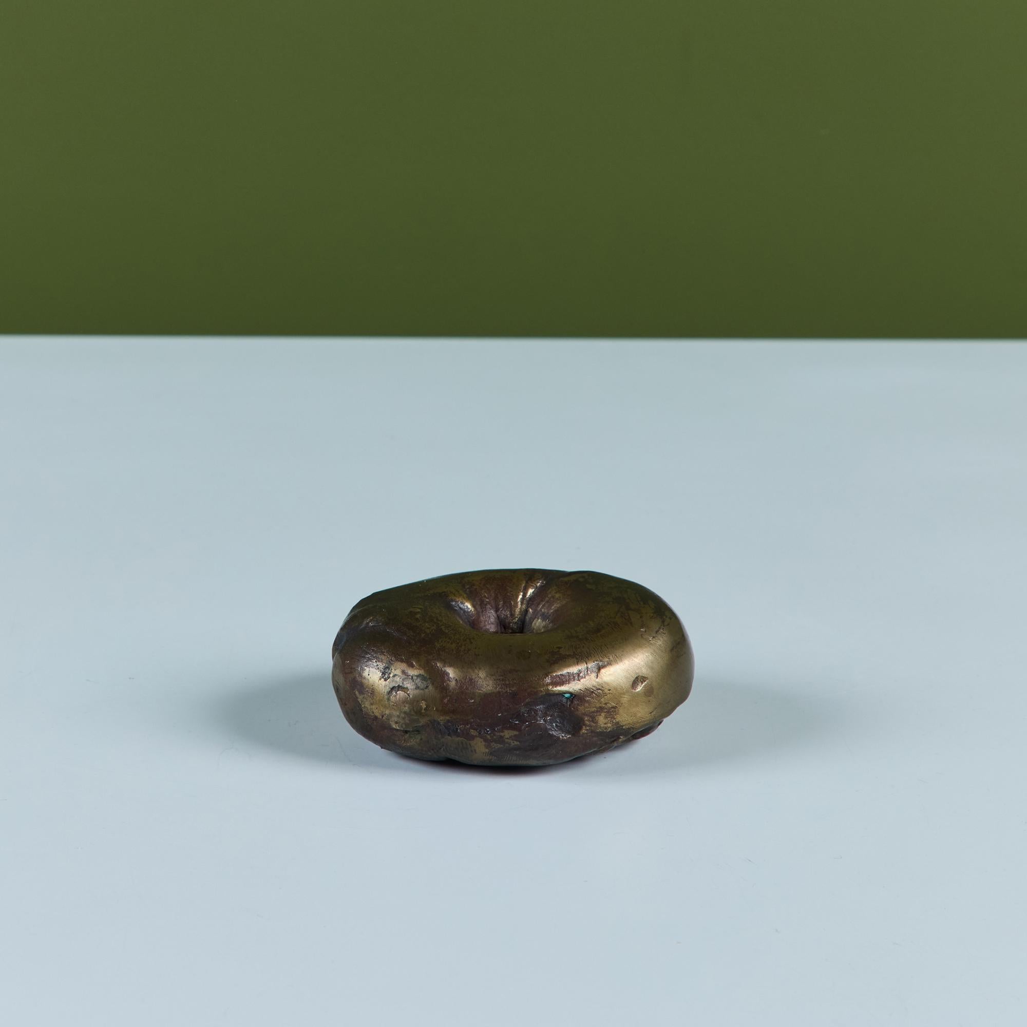 Passami la schmear! Questa giocosa scultura di bagel è l'aggiunta perfetta alla tua cucina come fermacarte di un libro di cucina o come decorazione di una mensola.  Firmato - WC Quirt 66' - 9/12

Dimensioni
3,5