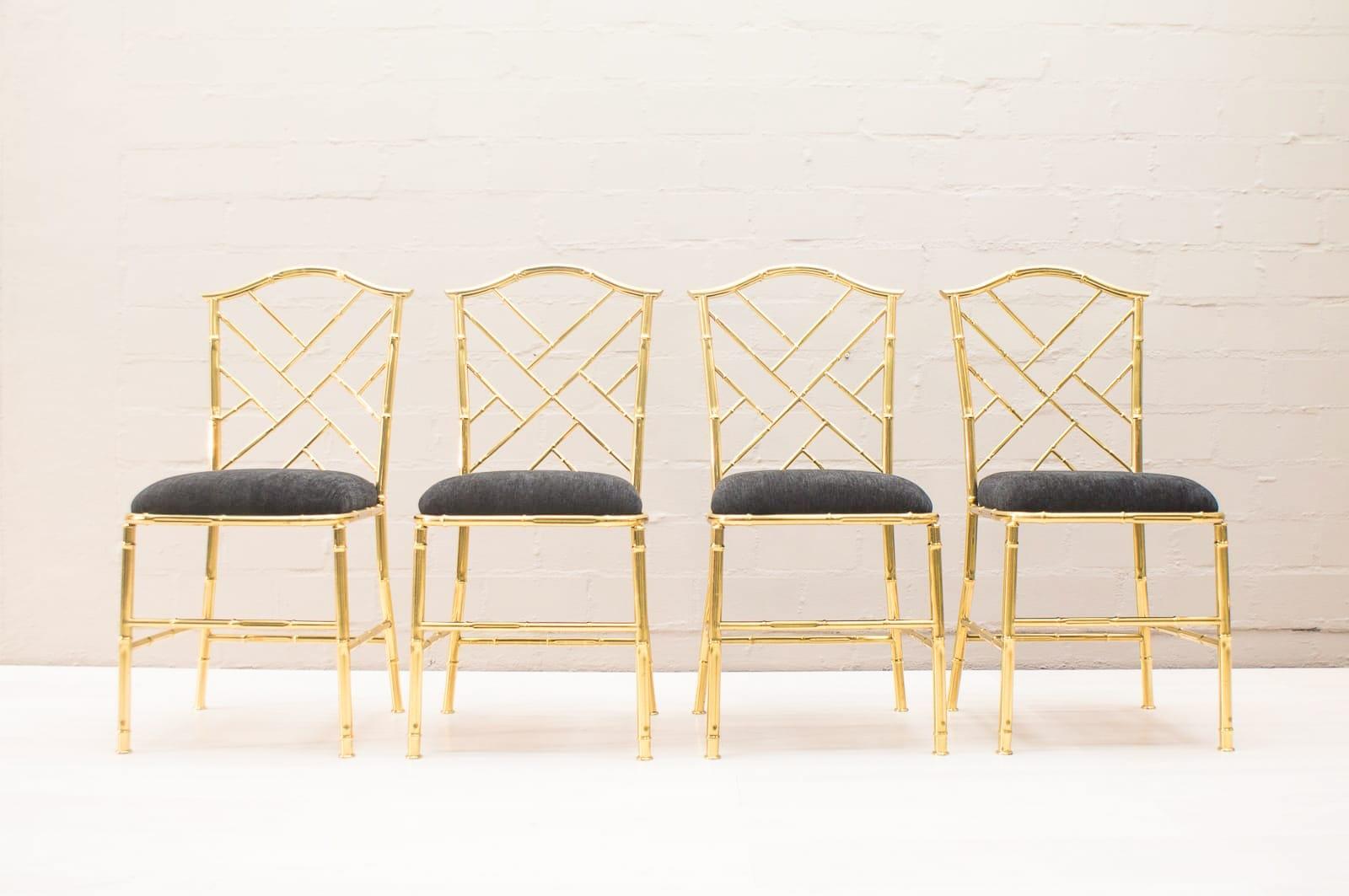 These four dining chairs are made of brass and bamboo in the 1960s. Light wear consistent with age and use, some scratches. New upholstery. Measures: Seat height 46 cm.