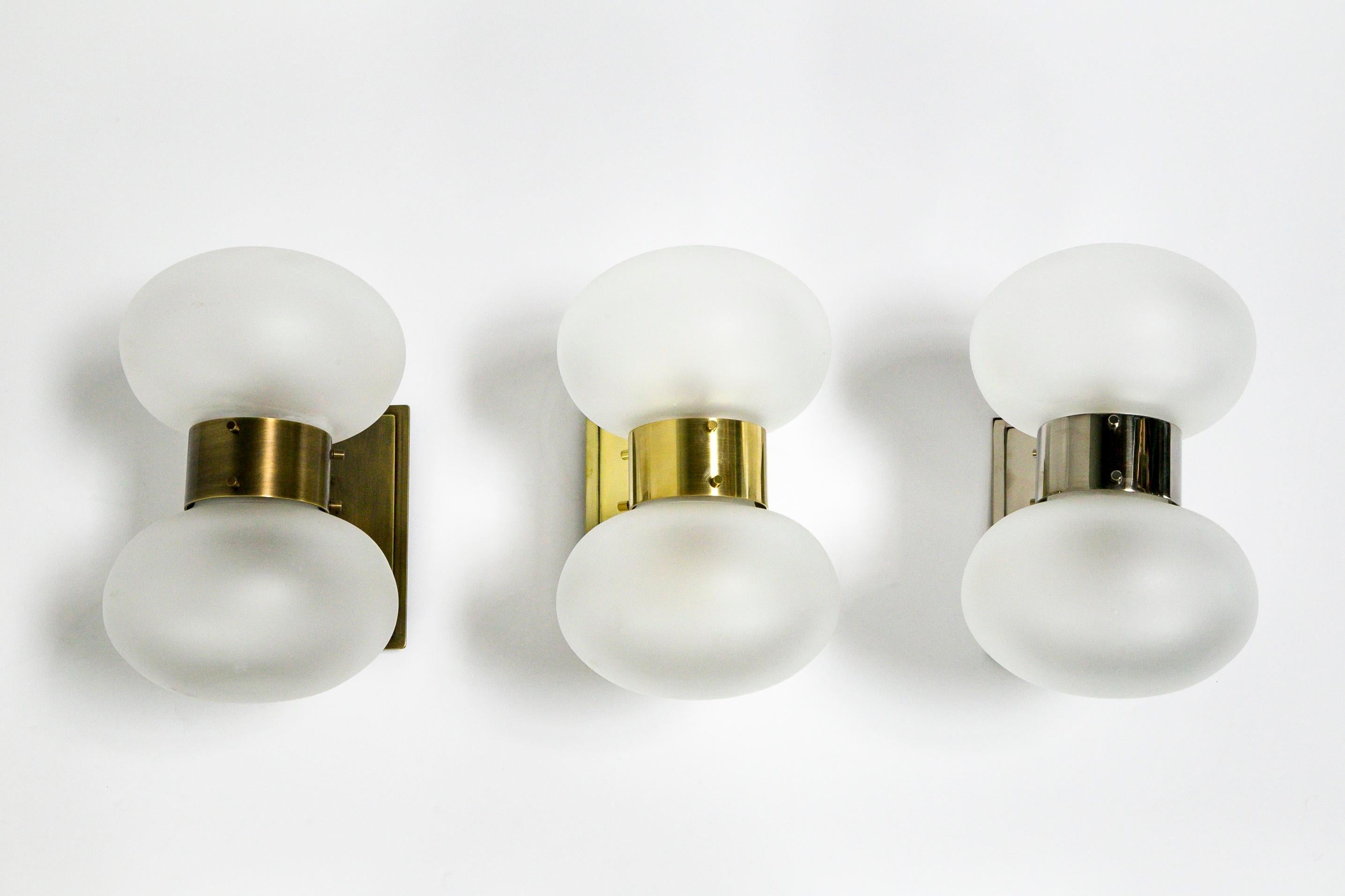 This handsome sconce features a beautifully unique frosted glass shape. The shade's round shape is contrasted with the geometric lines of the brass base and arm. It is having a sleek look with the stacked metal and covered screw details. The style